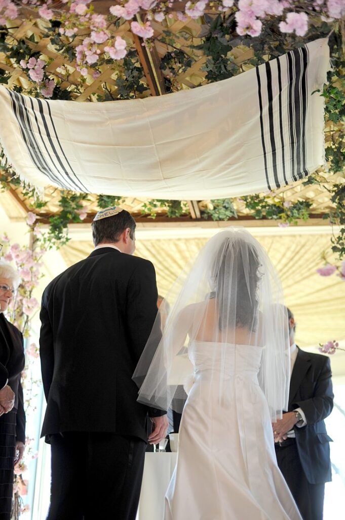 Bride and groom at their Tappan Hill Mansion wedding in Tarrytown, NY under a chuppah.