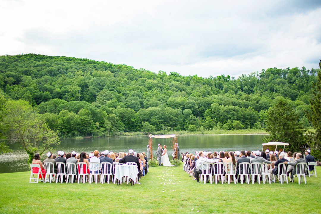 A ceremony overlooking the lake at Club Getaway. This sleepaway camp is the perfect venue for a fun wedding weekend. Photos by Mikkel Paige Photography.