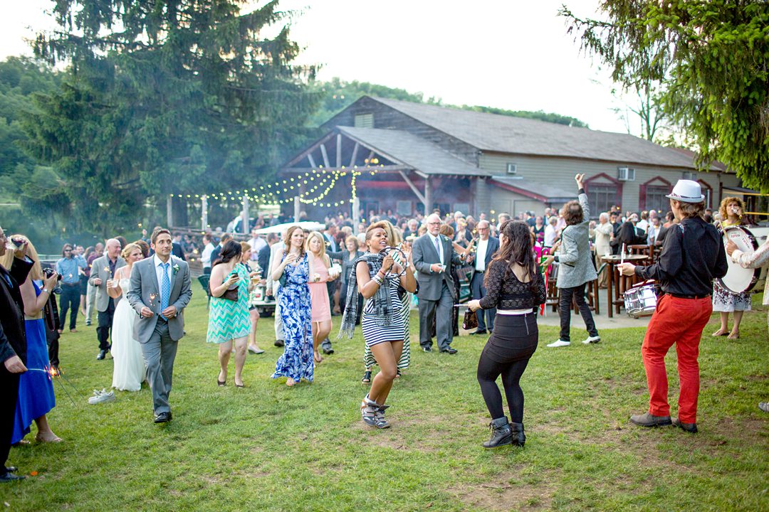 The band led a second line that had guests move from the cocktail hour to the dance floor and reception tent for a summer camp wedding photographed by Mikkel Paige Photography at Club Getaway.