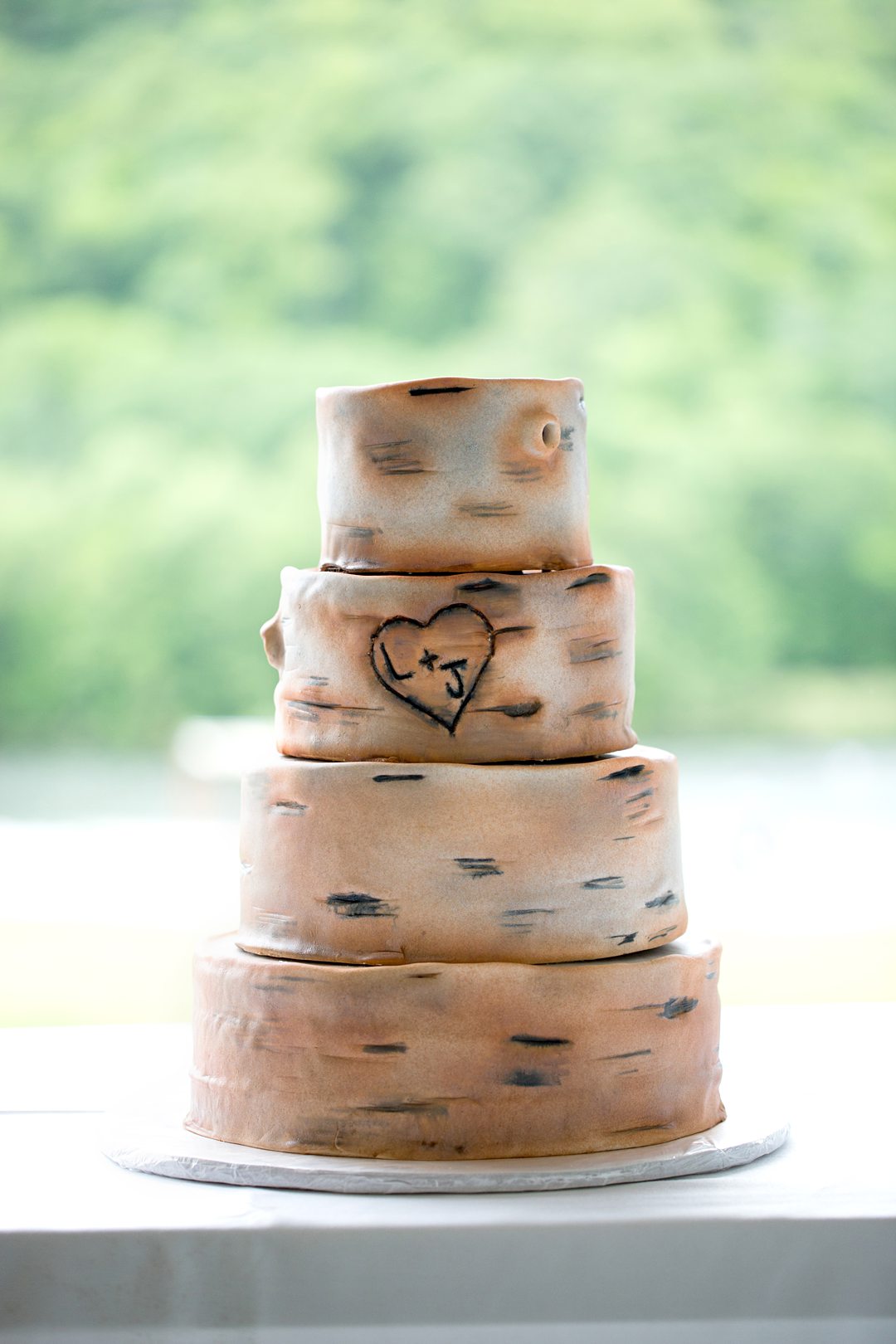 The cake was tiers covered in fondant and made to look like bark of a tree for a summer camp wedding photographed by Mikkel Paige Photography at Club Getaway.