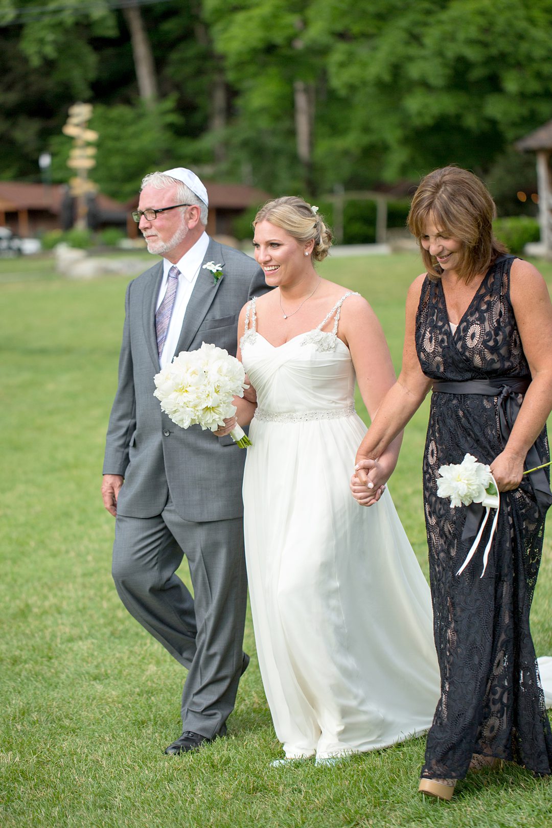 The bride and her parents walk down the aisle during a ceremony at Club Getaway. Photographed by destination photographer Mikkel Paige Photography.