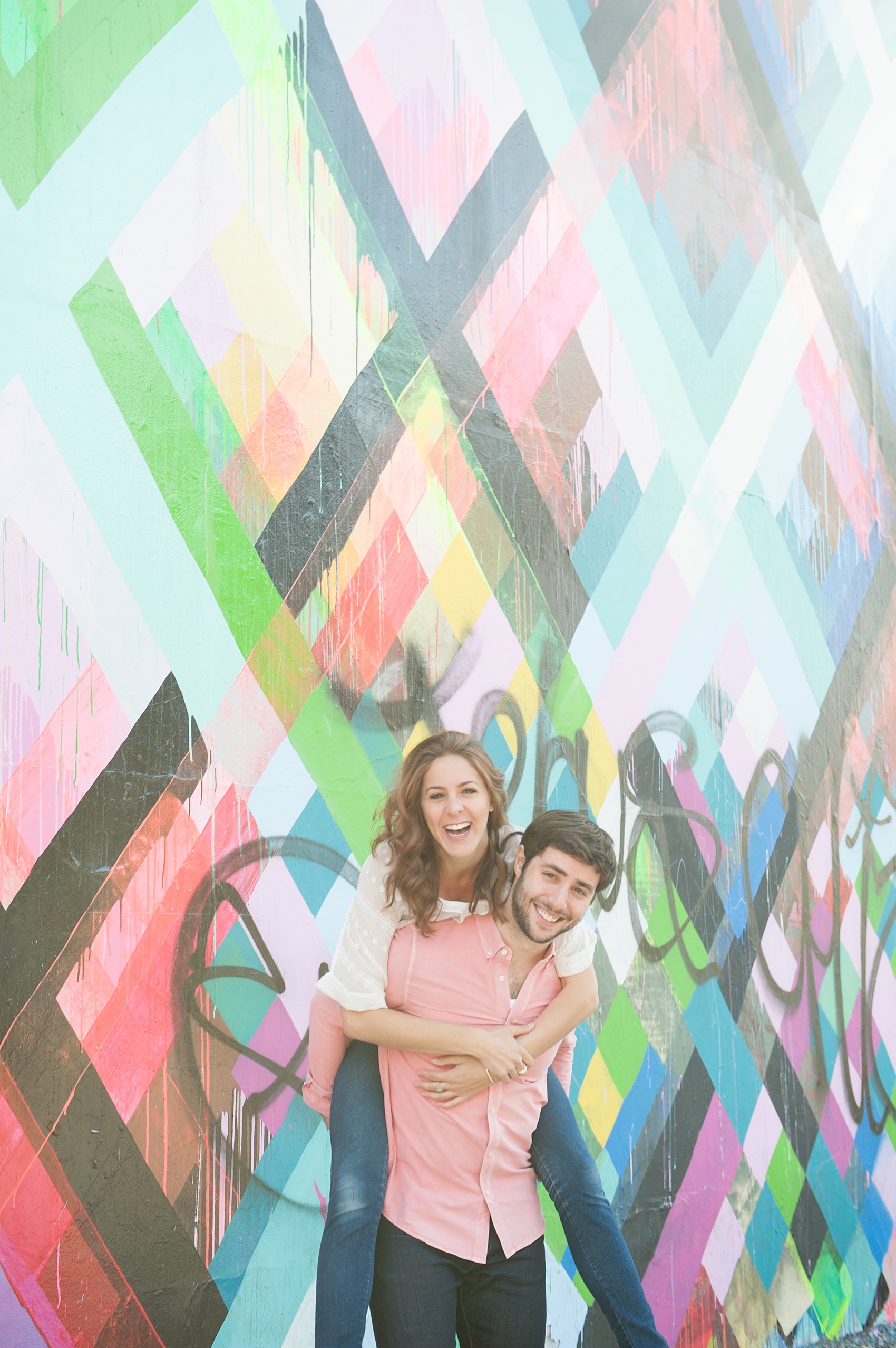 Couple's session at the Maya Hayuk geometric neon mural wall on Bowery Street in Manhattan. Photos by NYC wedding photographer, Mikkel Paige Photography.