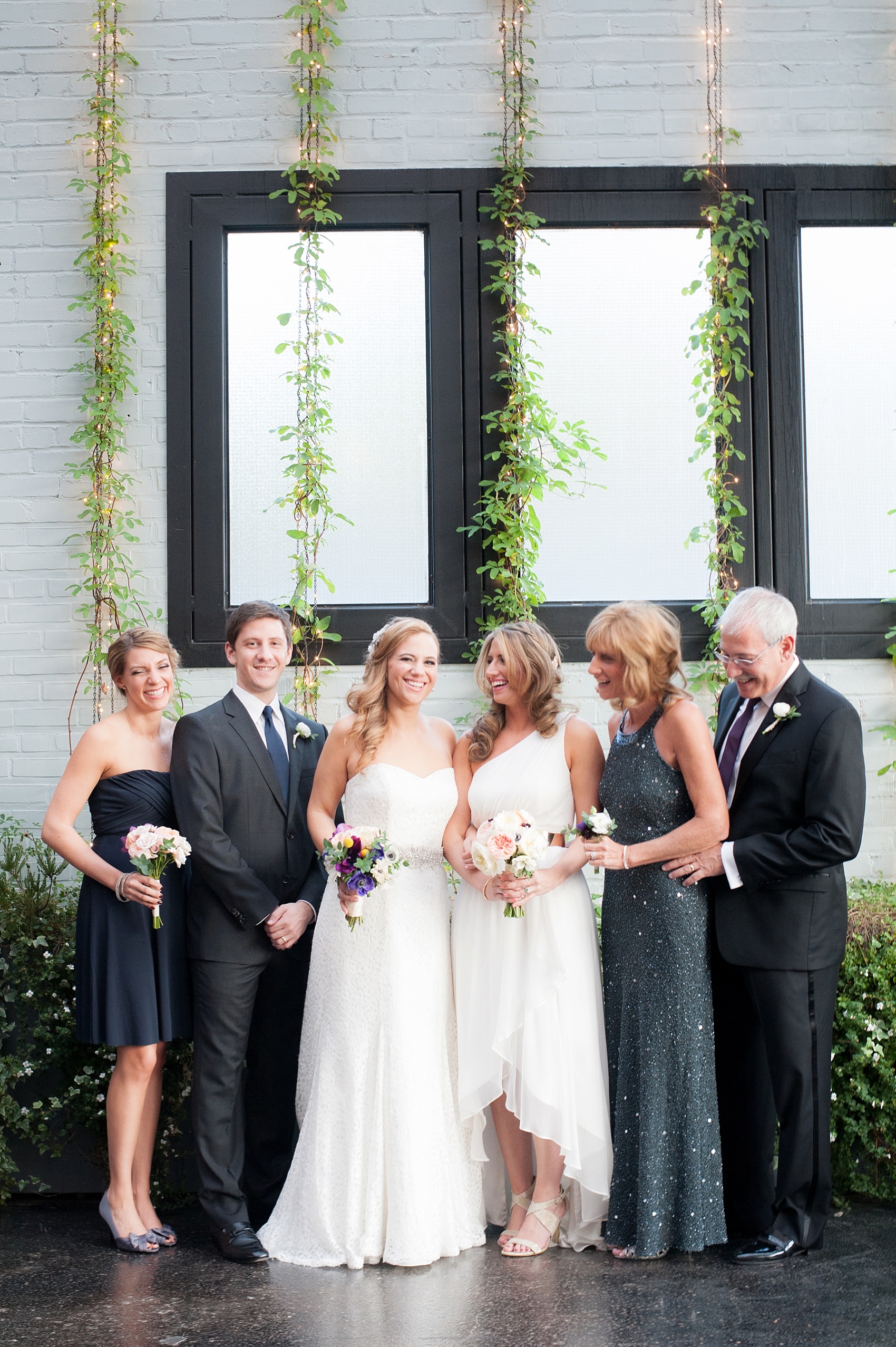 Wedding gowns by Jenny Yoo and Henry Roth, flowers by Foxglove and navy Ann Taylor bridesmaid dress in navy for a lesbian wedding at 501 Union, Brooklyn, NY. Photography by Mikkel Paige, NYC wedding photographer.