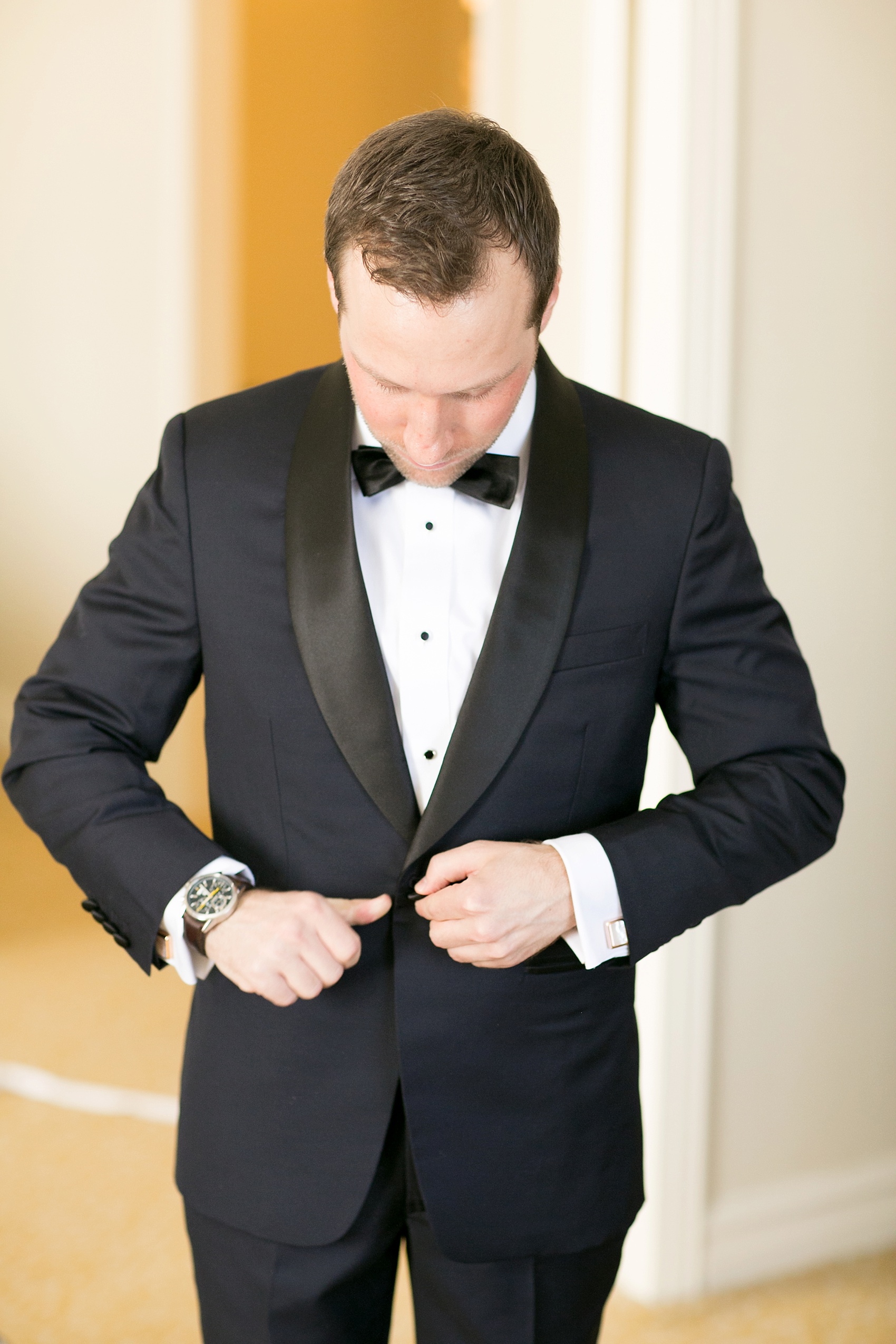 Washington, DC wedding photos by Mikkel Paige. The groom in a custom navy and black tuxedo for a Presidents Weekend wedding at The Ritz Carlton, Pentagon City.