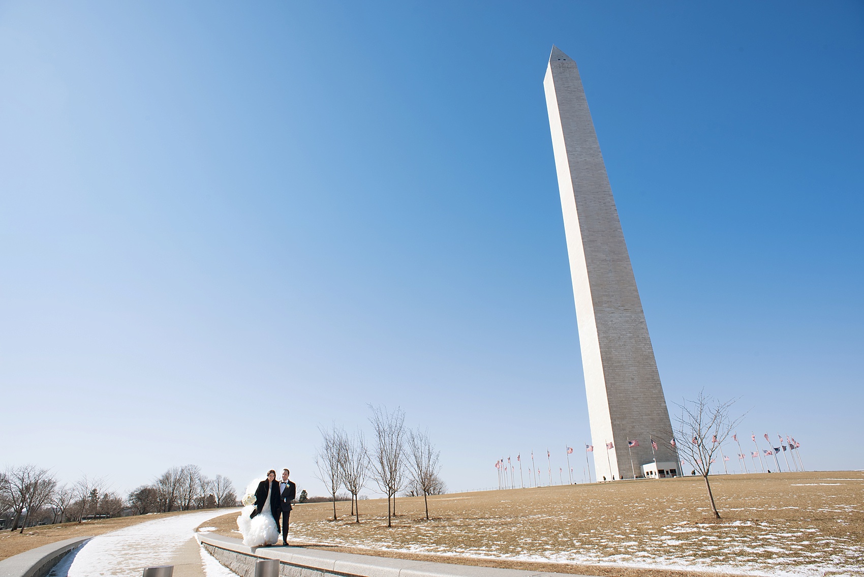 Washington, DC wedding photos by Mikkel Paige. The bride and groom take photos on the National Mall with the Washington Monument.