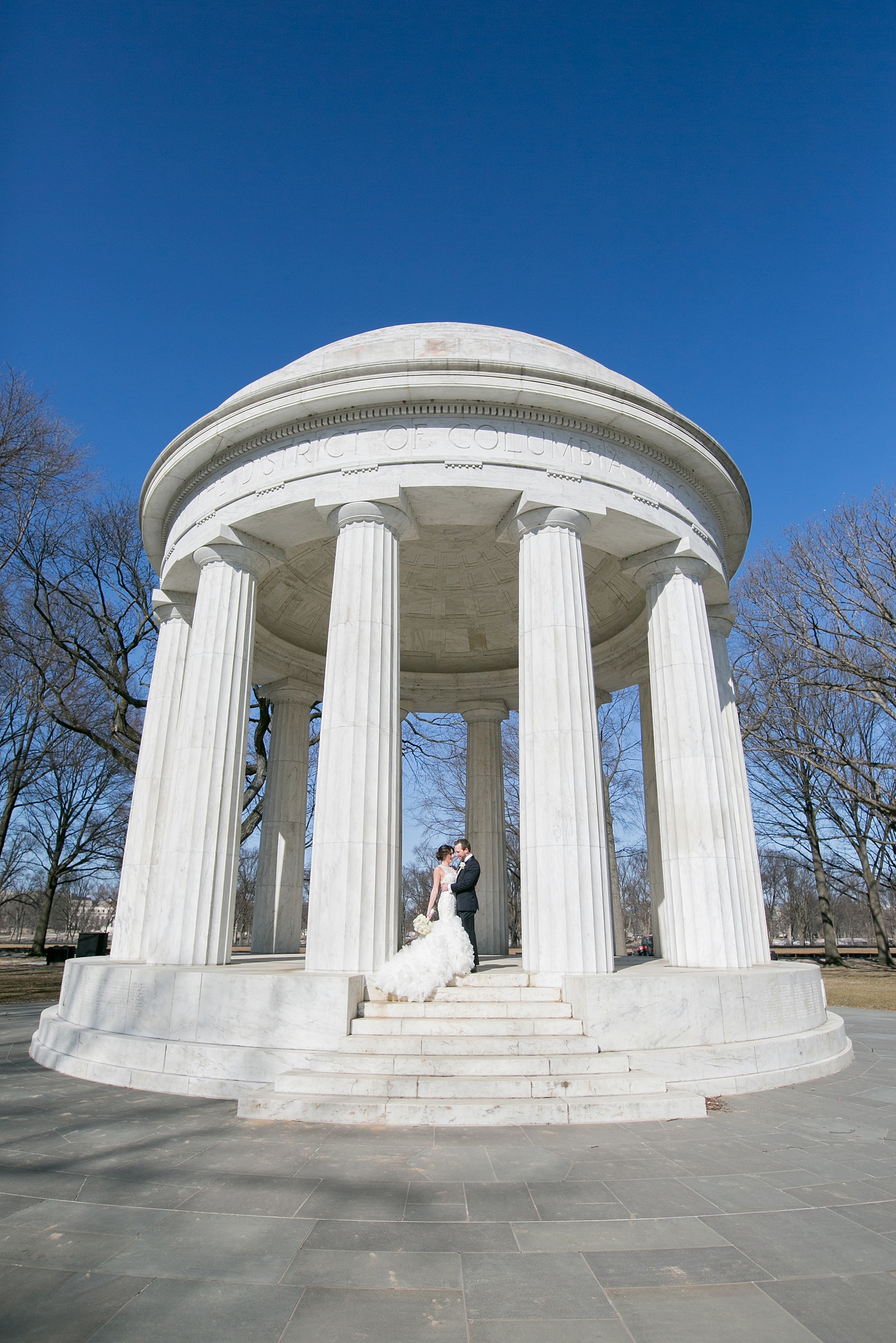 Washington, DC wedding photos by Mikkel Paige. The bride and groom take photos on the National Mall with the DC war memorial and stoic white columns.