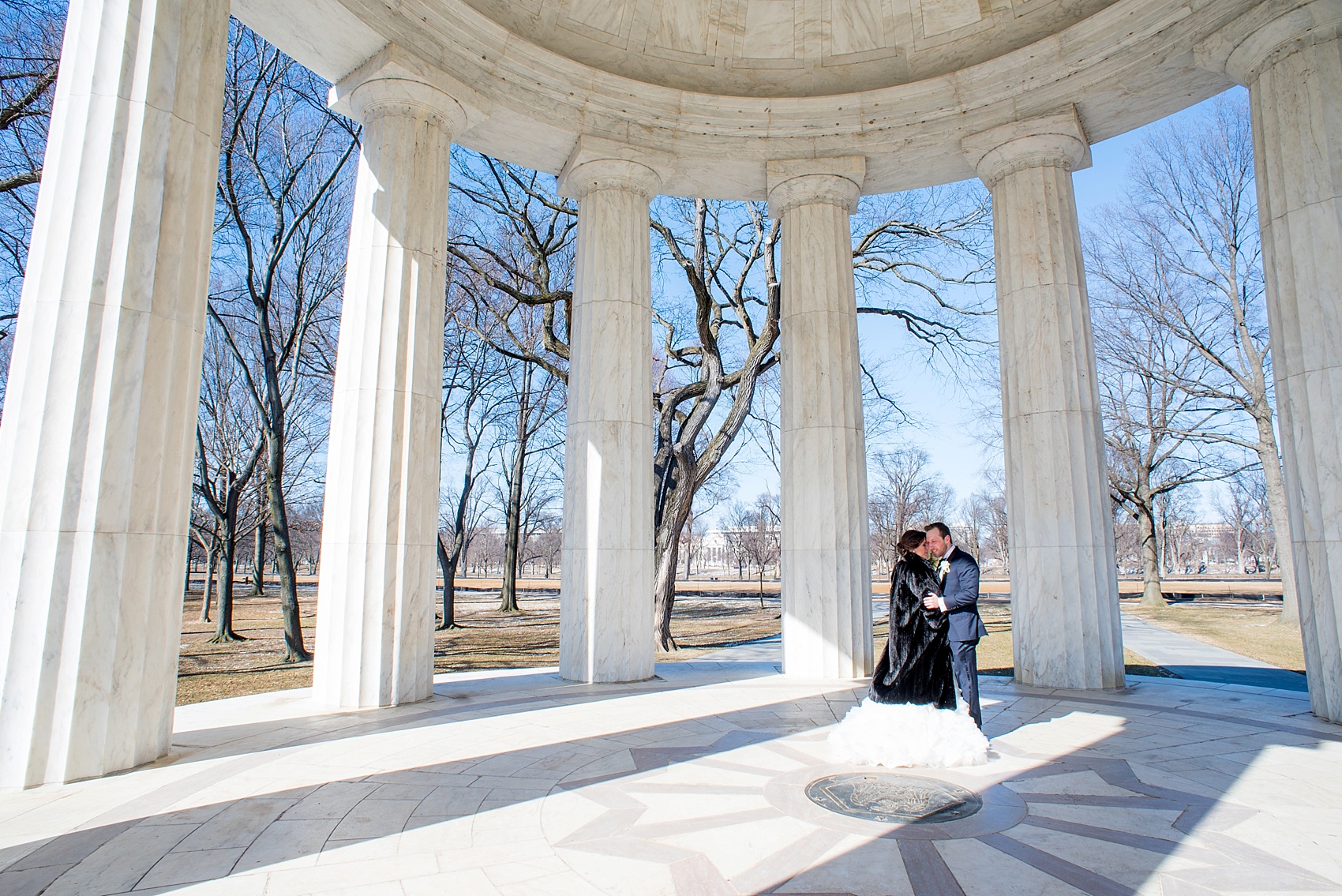 Washington, DC wedding photos by Mikkel Paige. The bride and groom take photos on the National Mall with the DC war memorial and stoic white columns.