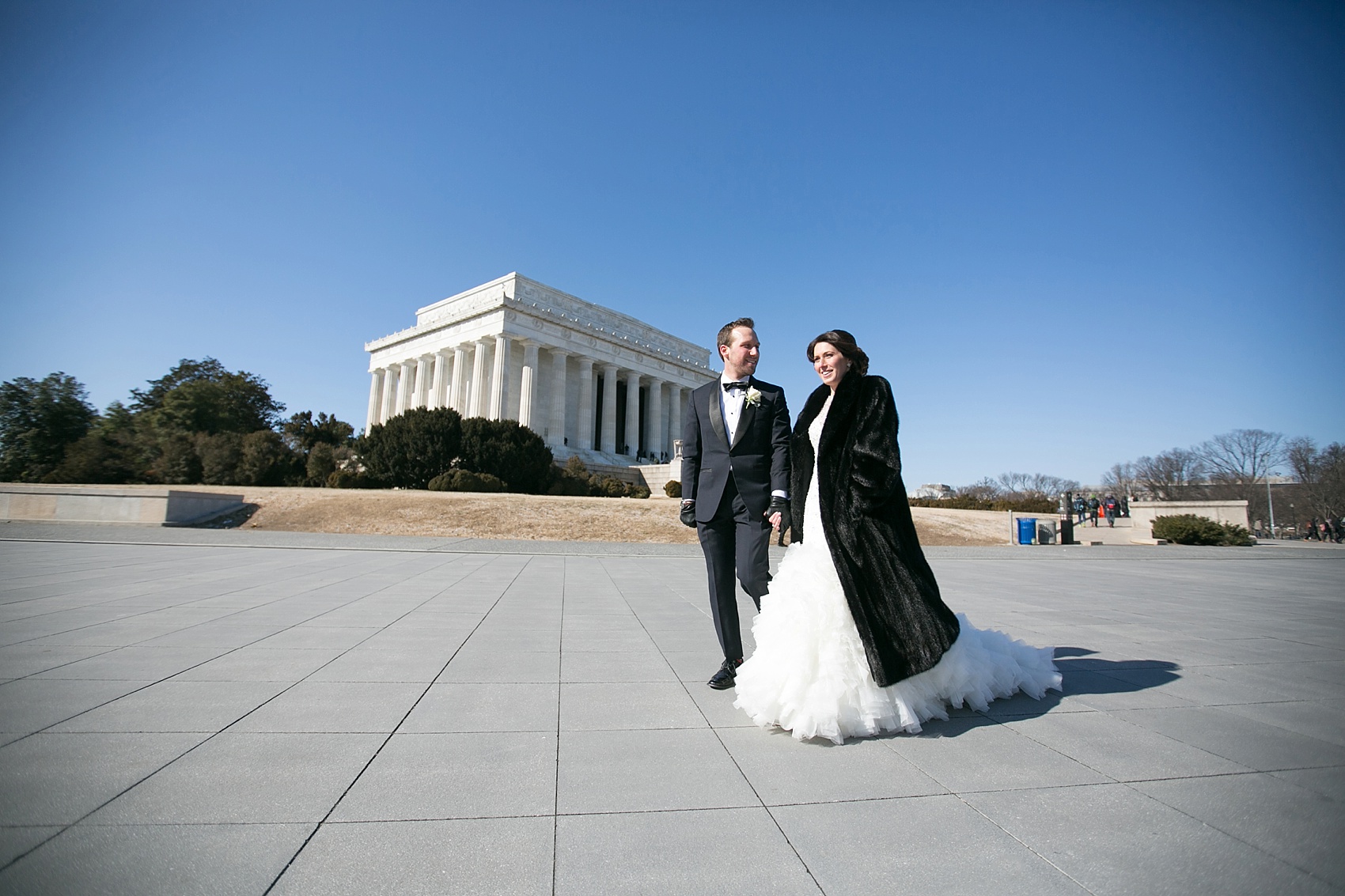 Washington, DC wedding photos by Mikkel Paige. The bride and groom take photos on the National Mall with the Lincoln Memorial.