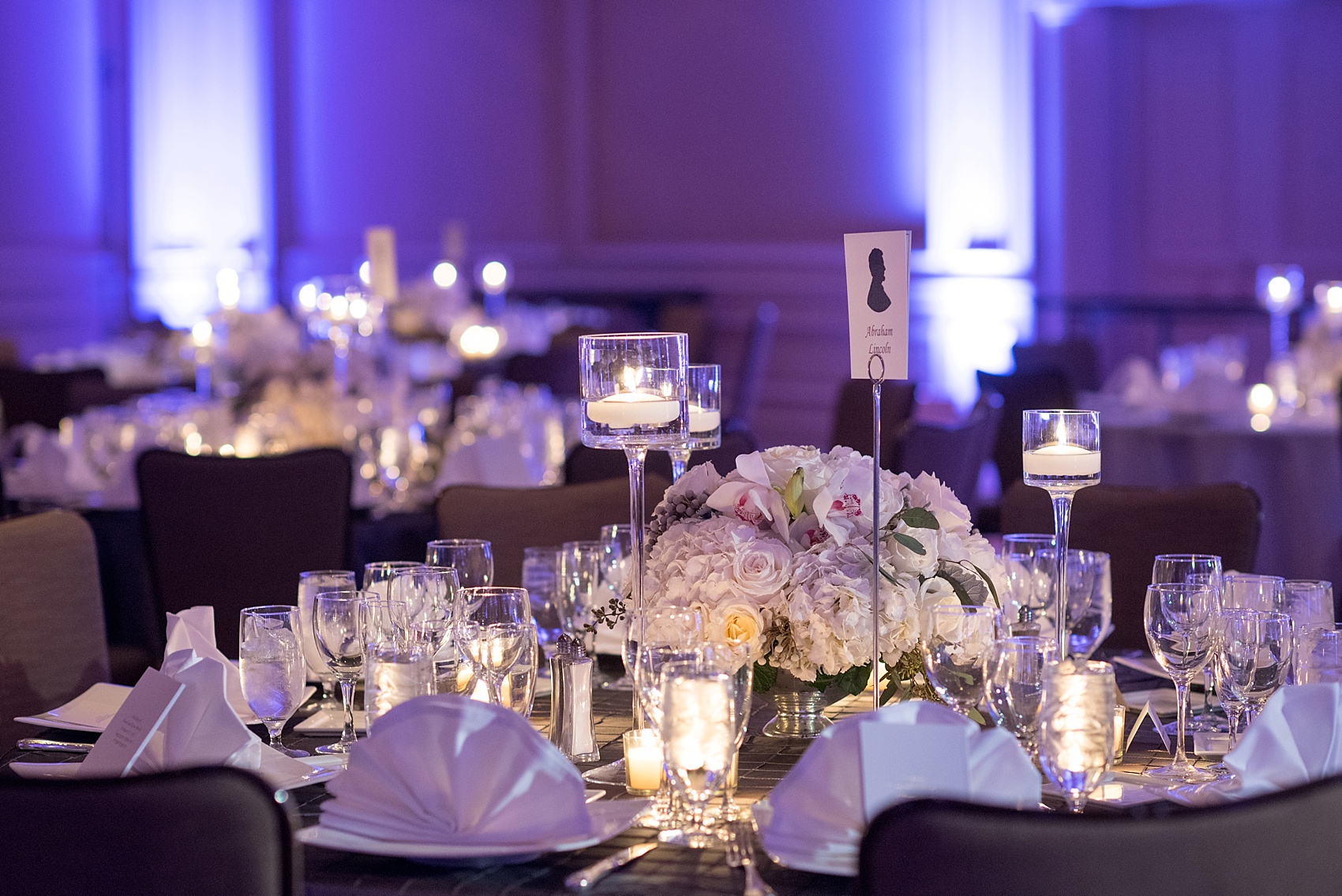 Washington, DC wedding photos by Mikkel Paige. The main ballroom with purple lighting and white flowers at the Ritz Carlton, Pentagon City.