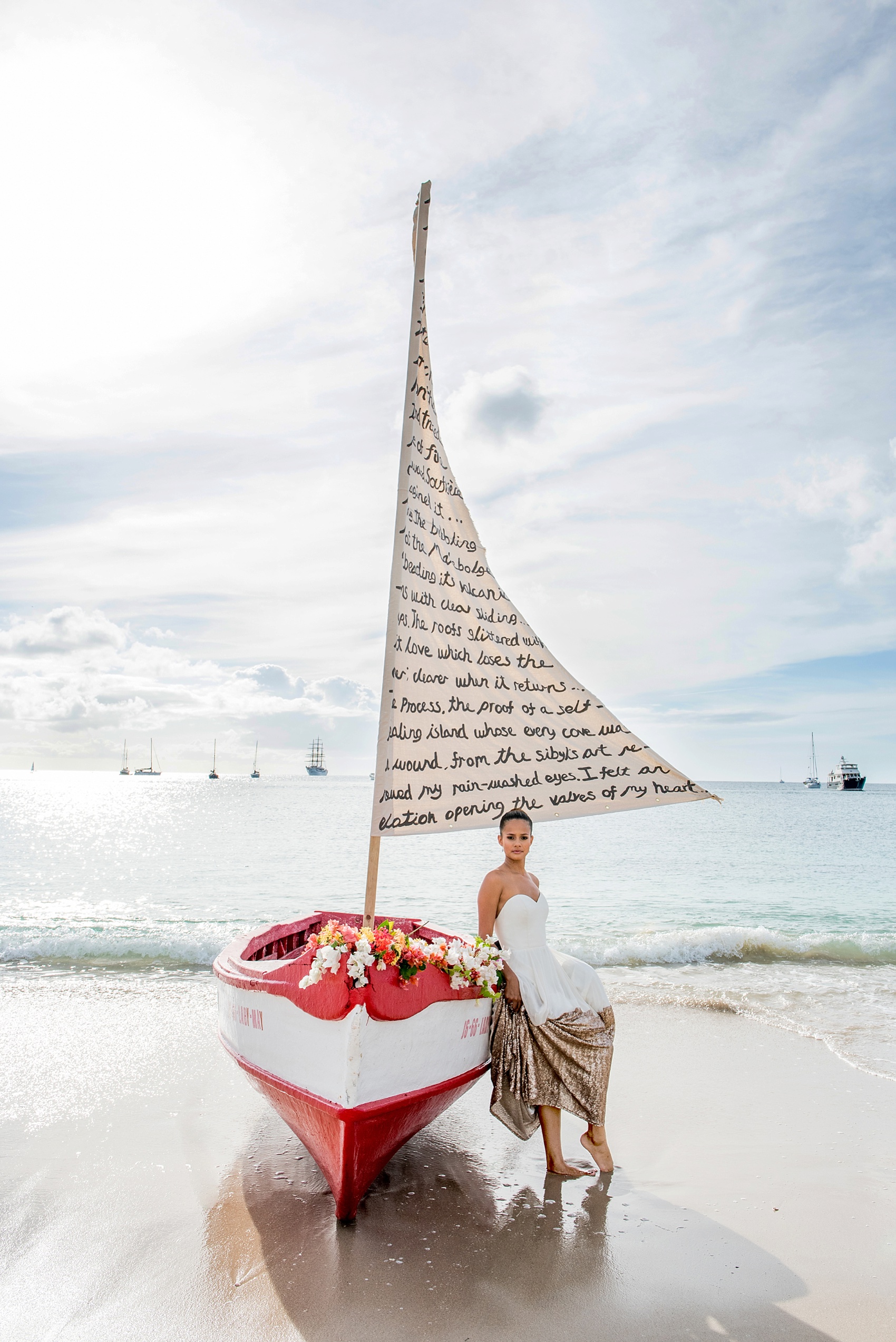 St. Lucia destination wedding beach elopement by Mikkel Paige Photography, at The Landings. Calligraphy on a sail with a boat for two.