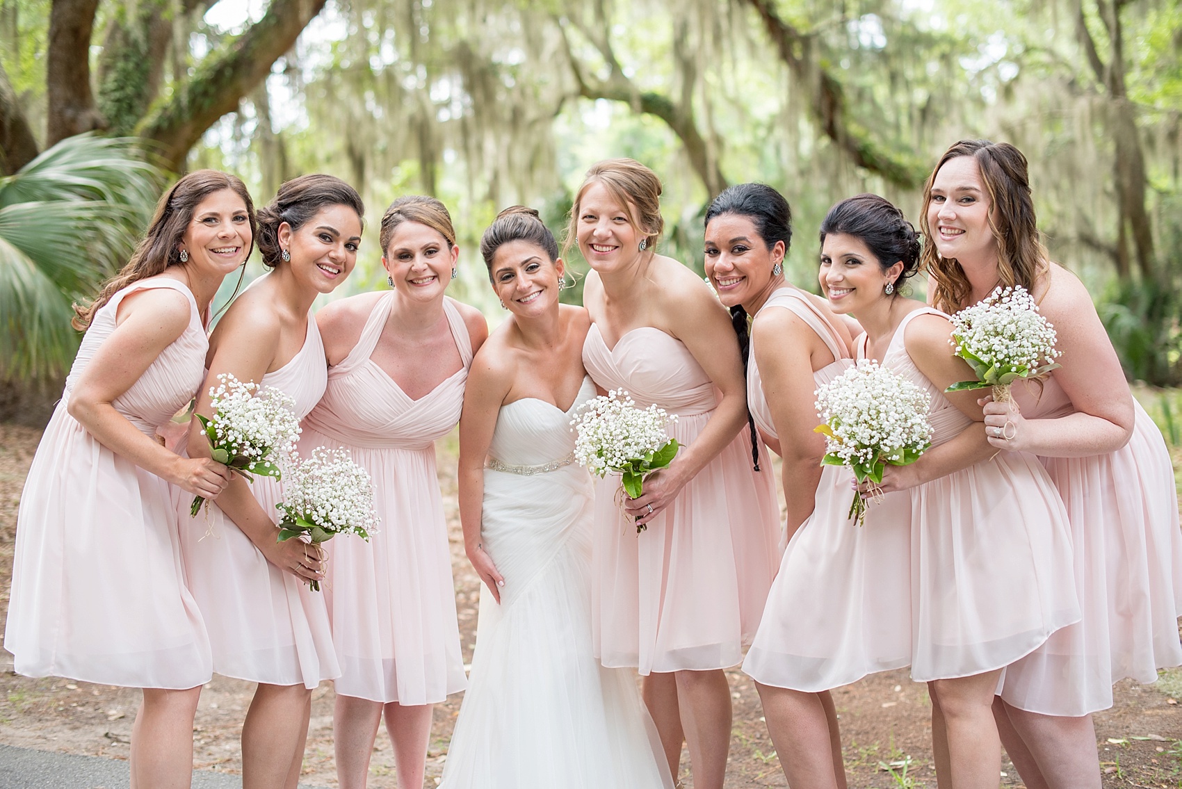 Bridesmaids in short pink Bill Levkoff dresses with Baby's Breath and Magnolia Leaf bouquets. Wedding party at Haig Point, South Carolina, off the coast of Hilton Head. Photos by Mikkel Paige Photography.