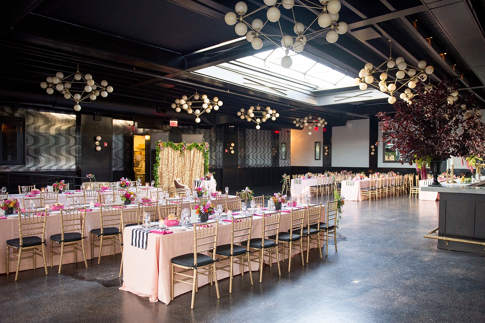 501 Union lesbian wedding. Photos by Mikkel Paige Photography, in Brooklyn, NYC. Planning by Ashley M Chamblin Events. Overall room photo with pink linens and brightly colored flower centerpieces. Gold sequin backdrop.
