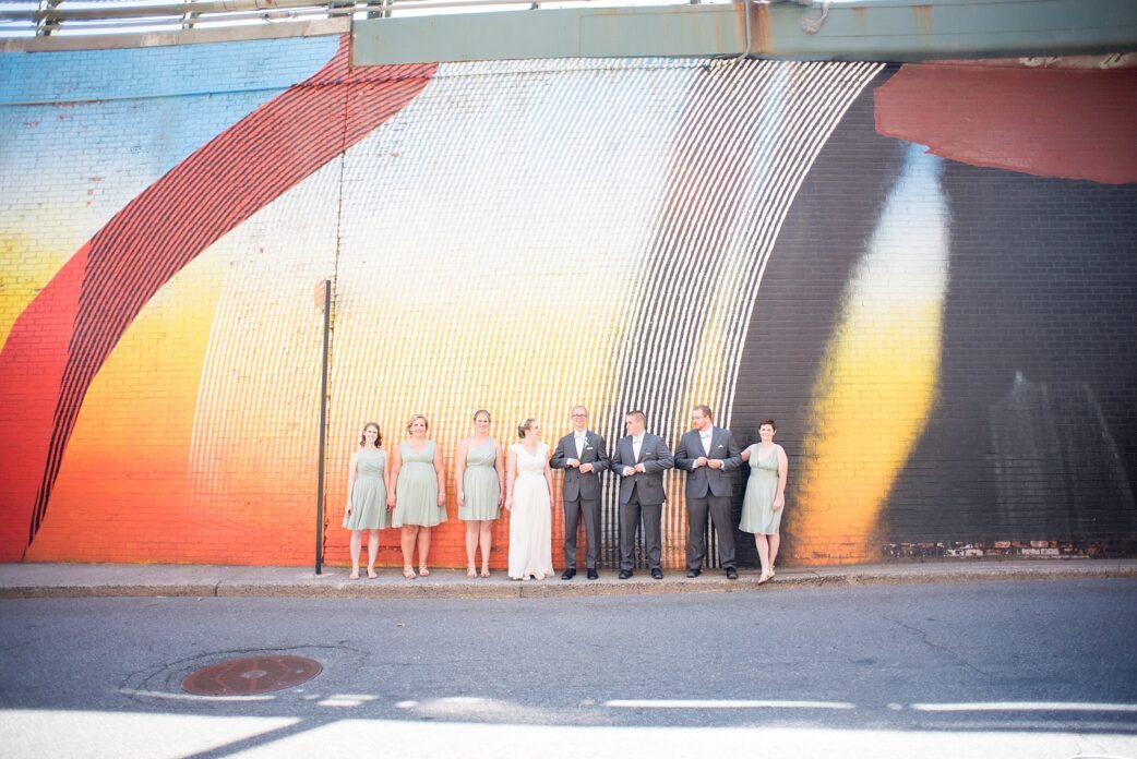 Neon graffiti wall wedding party photo in DUMBO, Brooklyn, New York. Photos by Mikkel Paige Photography, NYC wedding photographer.