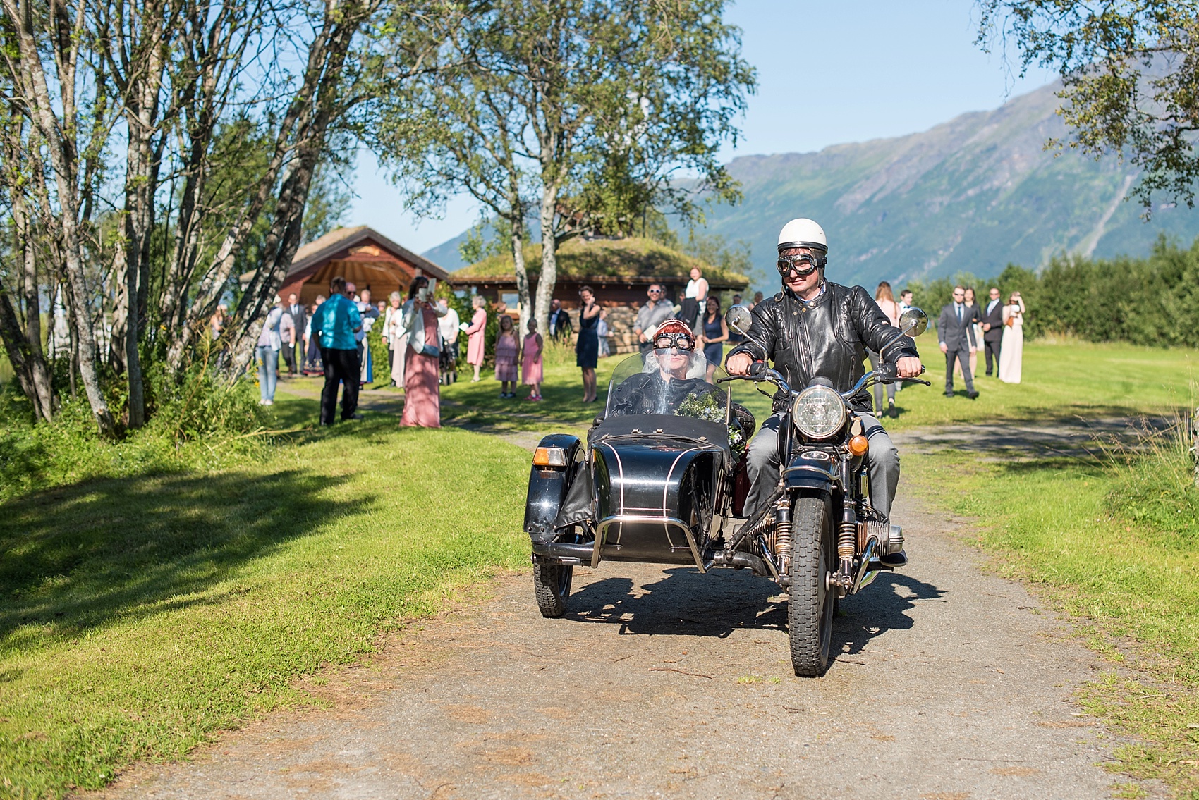 Norway wedding photos by Mikkel Paige Photography, destination wedding photographer. The bride and groom exit on a motorcycle!