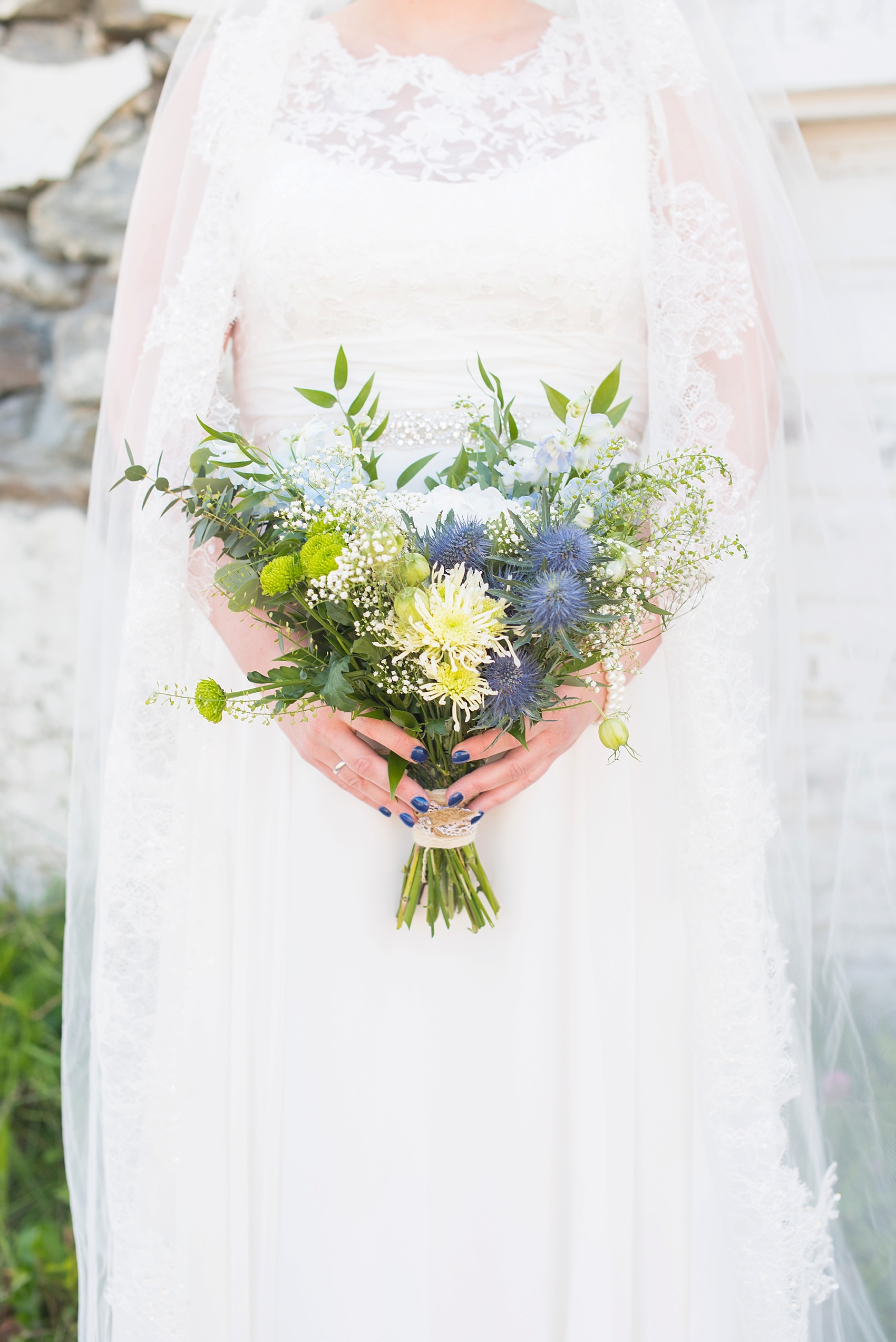 Norway wedding photos by Mikkel Paige Photography, destination wedding photographer. Rustic blue, white and green bouquet with mums and blue thistle tied with twine.