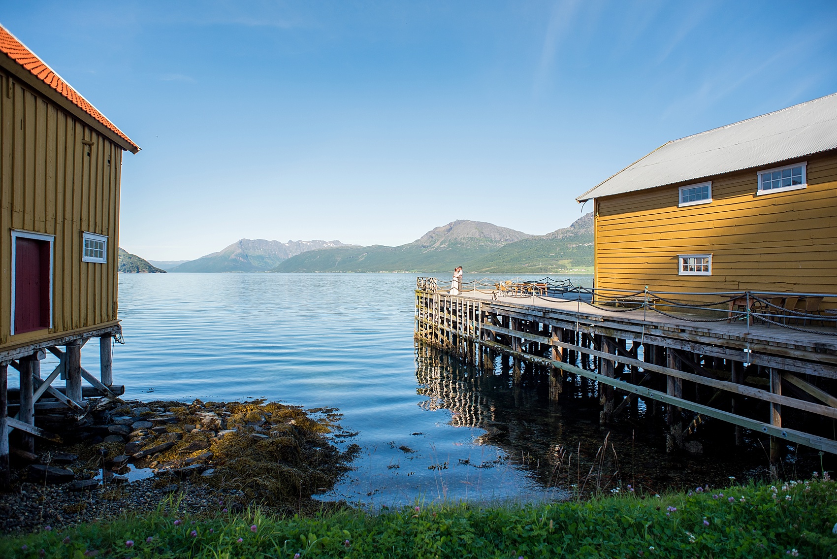 Norway wedding photos by Mikkel Paige Photography, destination wedding photographer. Picturesque bride and groom photo on the water with mountains.