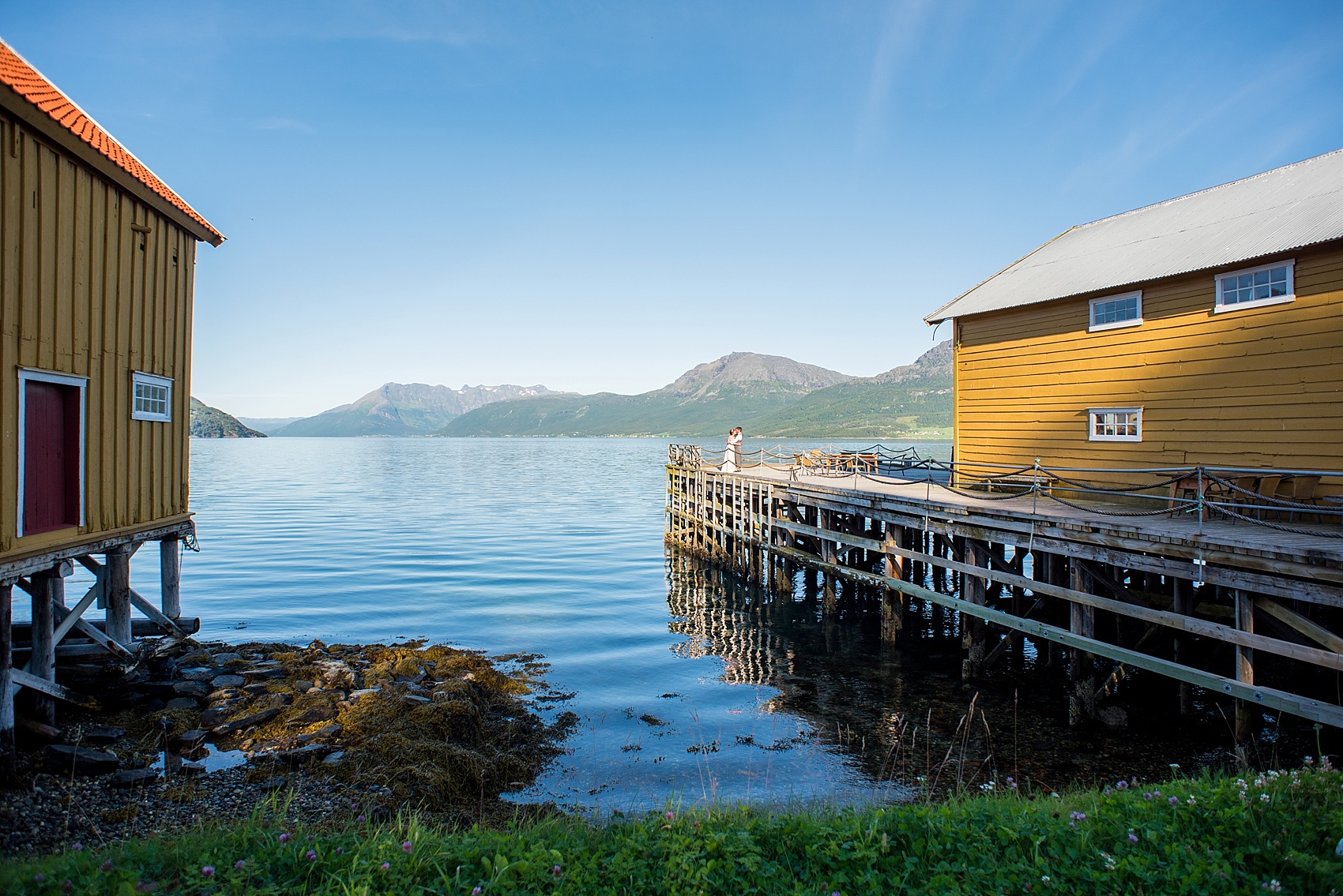 Norway wedding photos by Mikkel Paige Photography, destination wedding photographer. Picturesque bride and groom photo on the water with mountains.