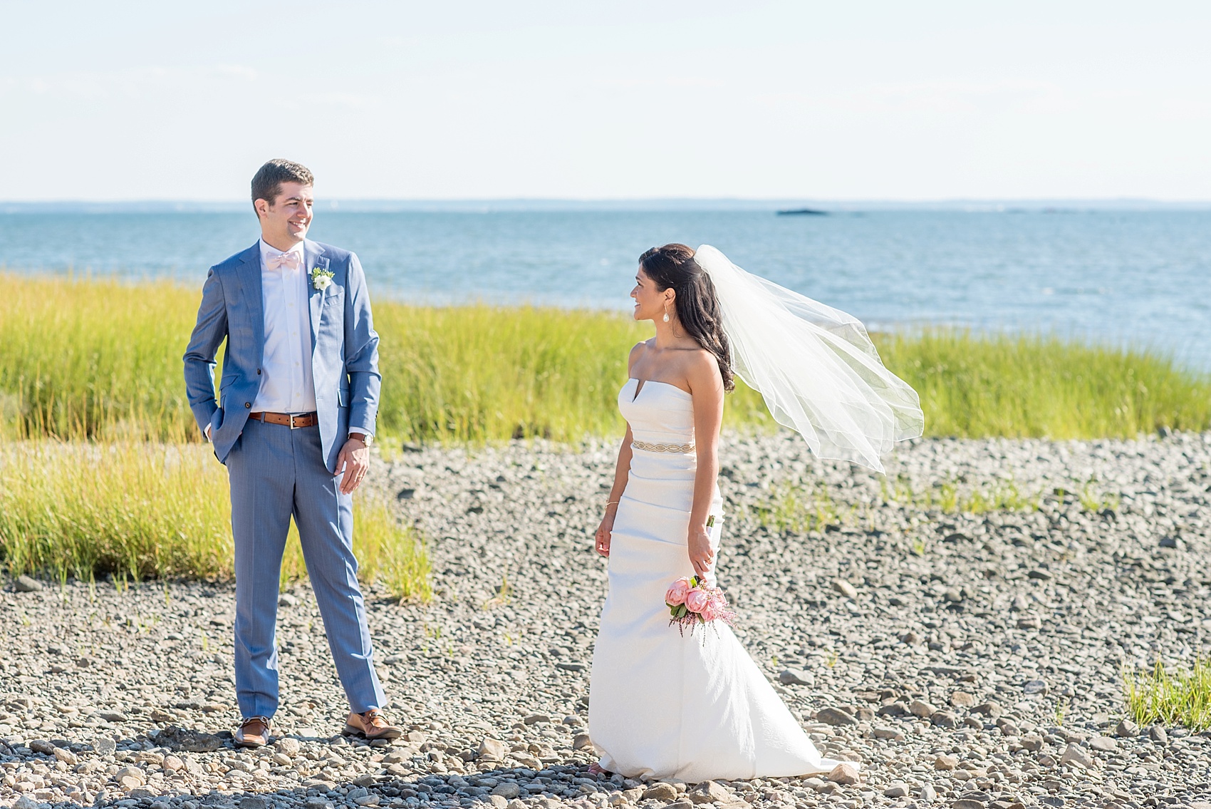 Connecticut beach wedding photos by Mikkel Paige Photography. Groom in blue suit and pink bow tie.