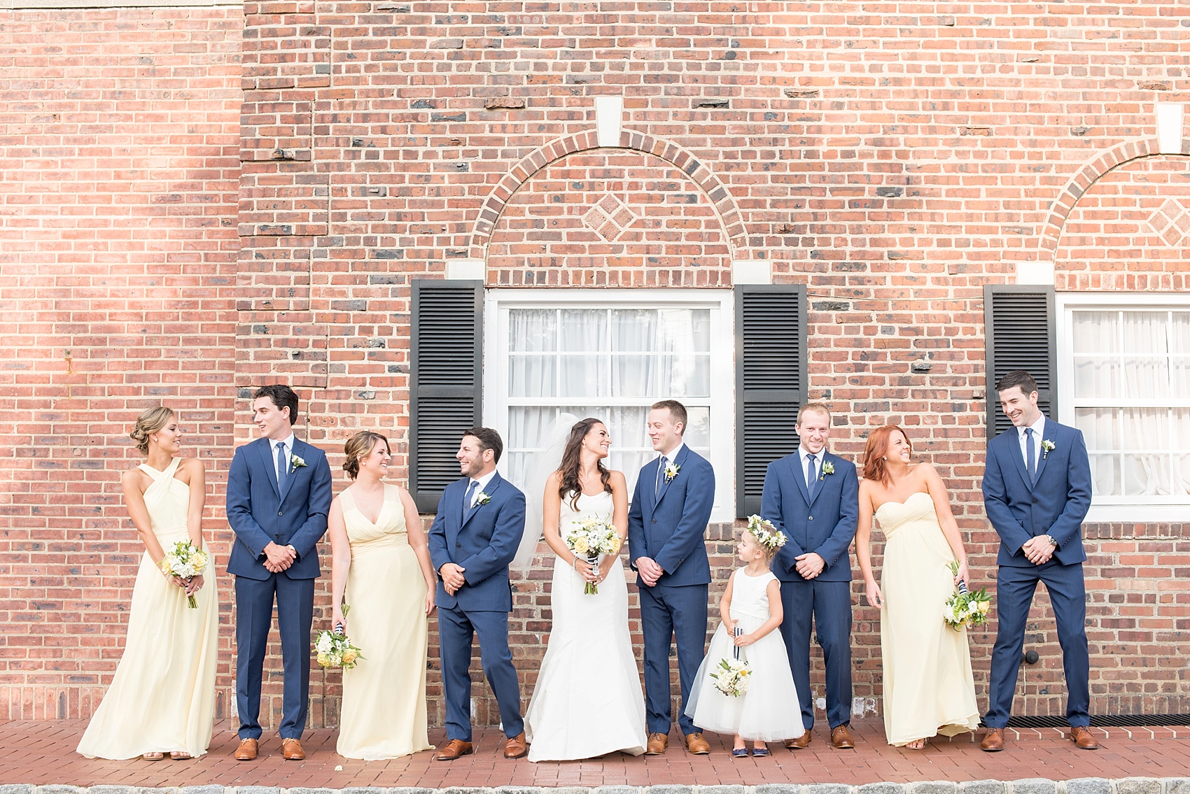 Wedding party in navy blue suits and yellow chiffon dresses for the groomsmen and bridesmaids in New Jersey for this nautical wedding at the Molly Pitcher Inn. Photo by Mikkel Paige Photography.