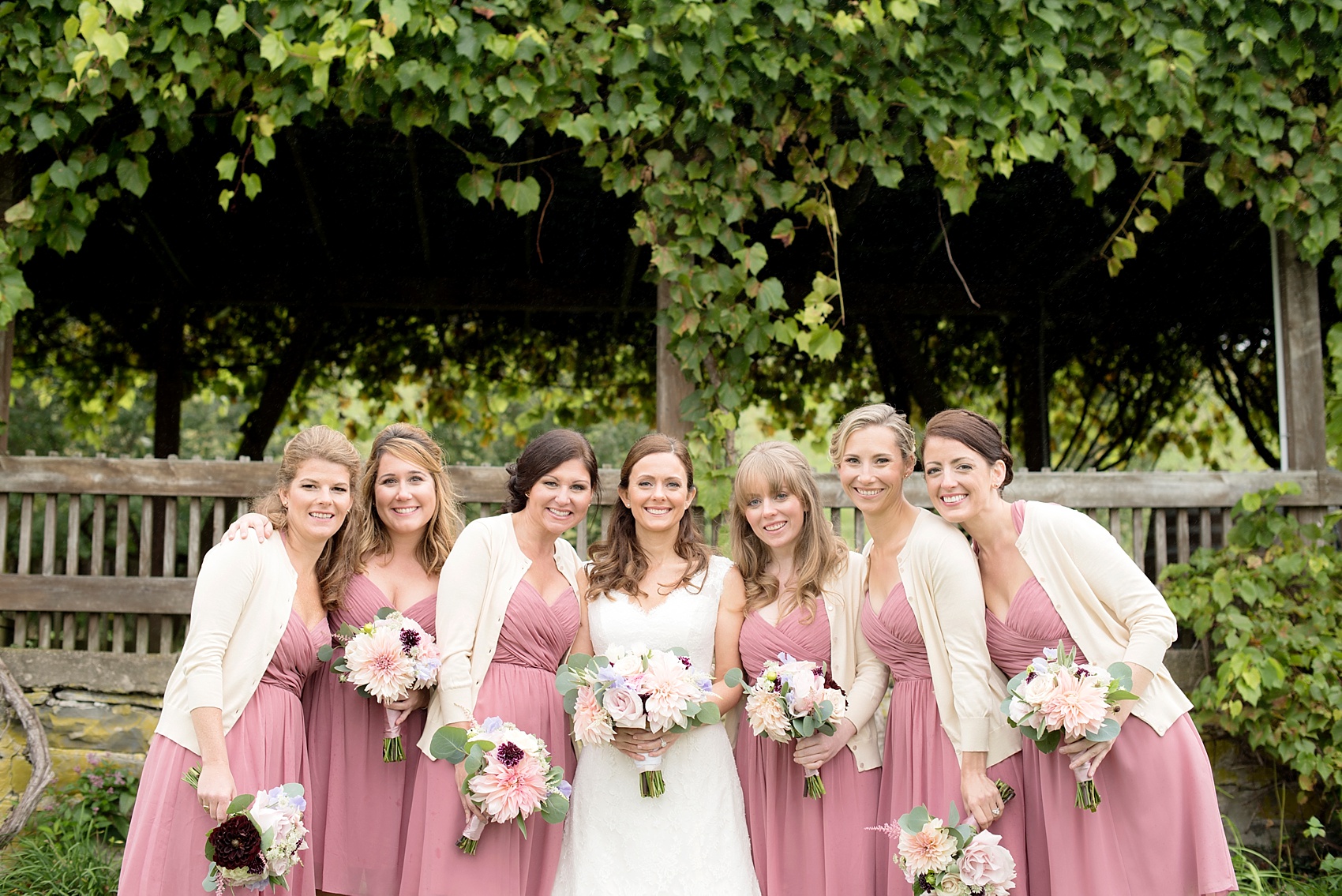 Red Maple Vineyard wedding. Photos by Mikkel Paige Photography. Bridesmaids in dusty rose short dresses and off white cardigans.