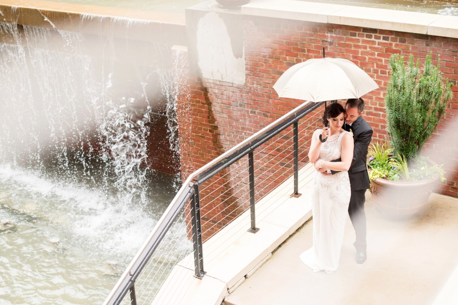 Bay 7 wedding photos by Mikkel Paige Photography. Raleigh wedding photographer takes images of bride and groom on a rainy day under an umbrella.