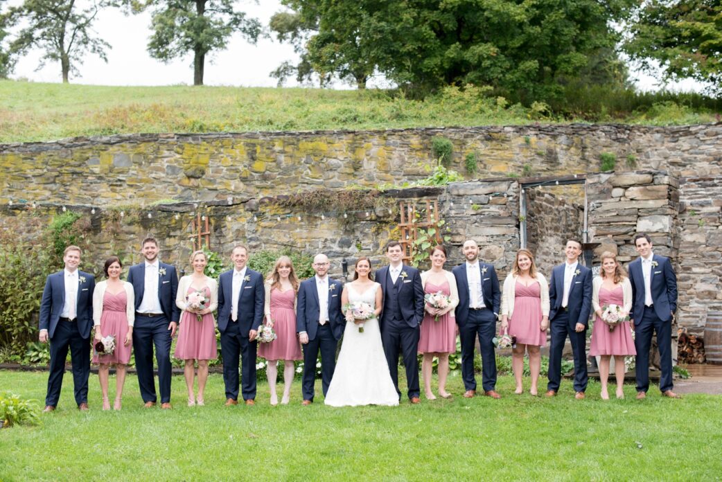 A Red Maple Vineyard wedding party with the bridal party in dusty rose dresses and groomsmen in navy. Photo by NYC wedding photographer Mikkel Paige Photography.