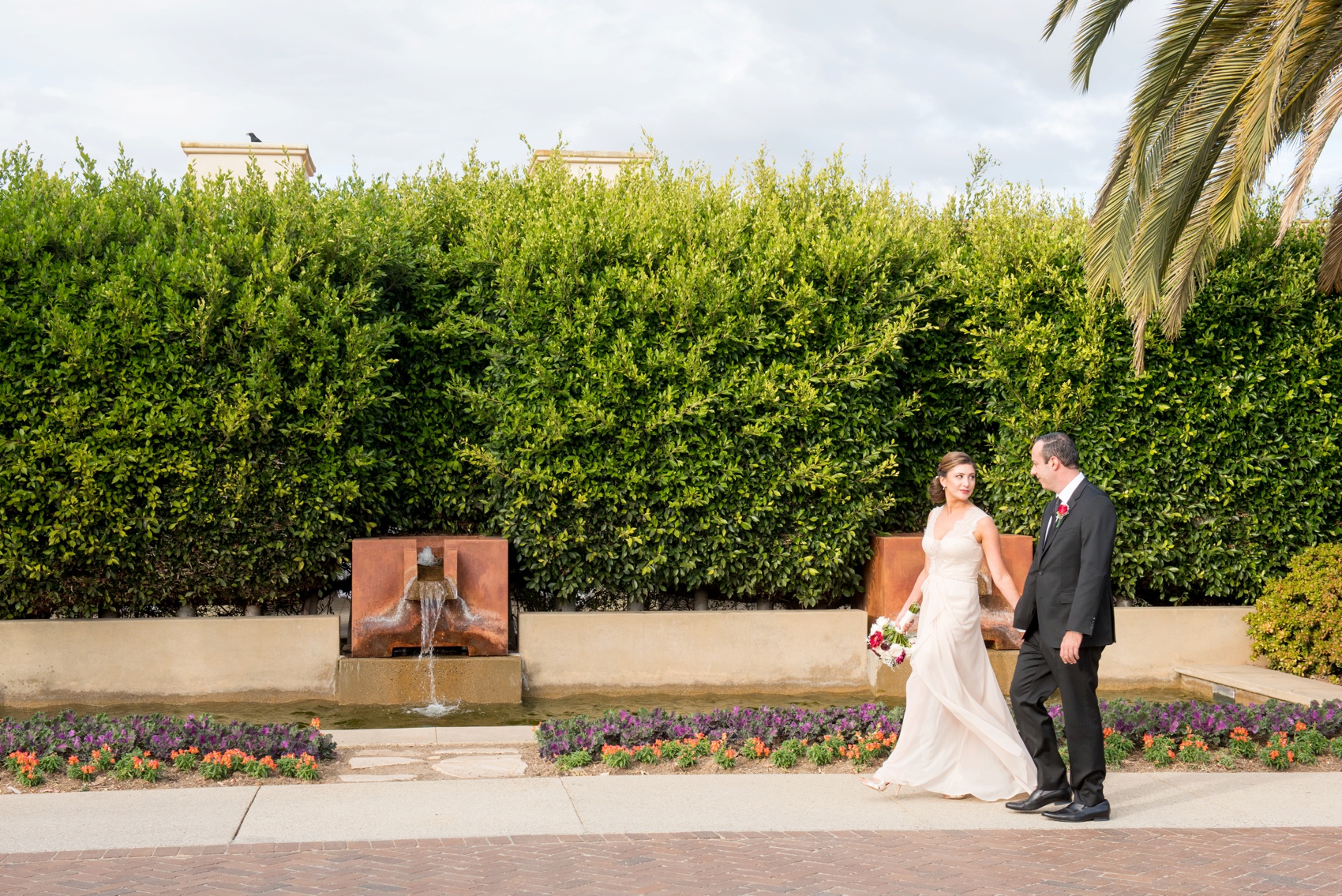 Estancia La Jolla wedding photography by Mikkel Paige Photography. Tropical wedding, California coast. Bride and groom photos. Bridal gown of lace and pink chiffon by BCBG Max Azria.