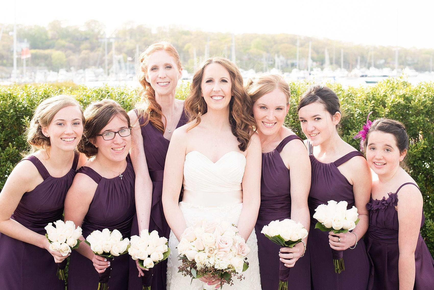 Photos by Mikkel Paige Photography for a wedding at Harbor Club on Long Island. Bride in a strapless white gown with bridesmaids in purple white white and pink roses.