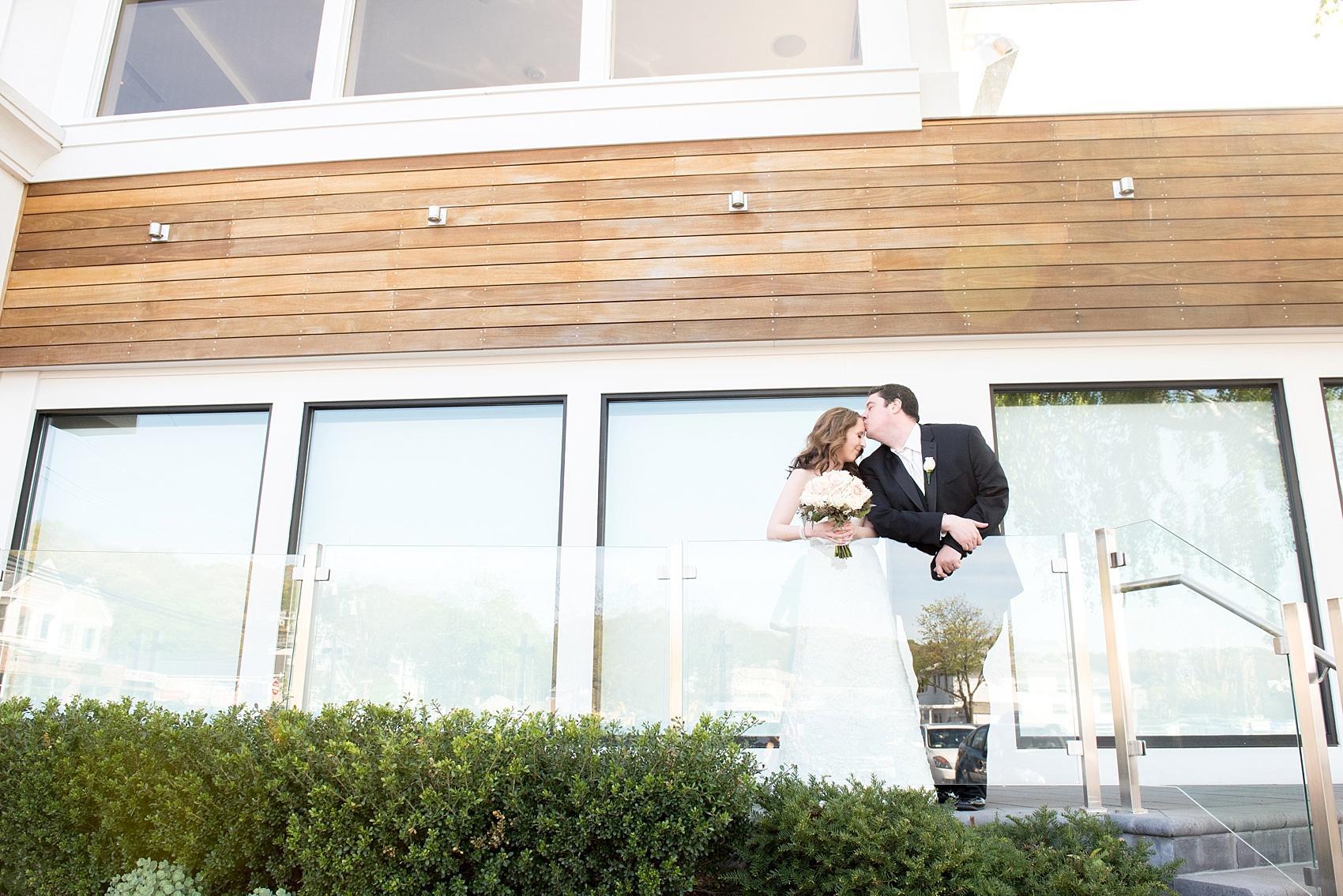 Photos by Mikkel Paige Photography for a wedding at Harbor Club on Long Island. First look on the balcony overlooking the water.