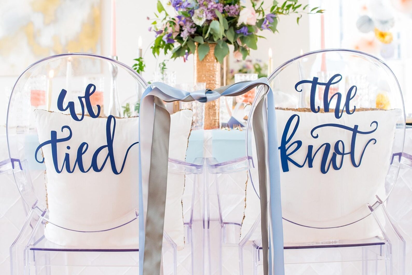 Mikkel Paige Photography at The Glass Box in downtown Raleigh for a Rose Quartz and Serenity Blue wedding. Unique bride and groom ghost chairs with "We Tied The Knot" ribbon detail.