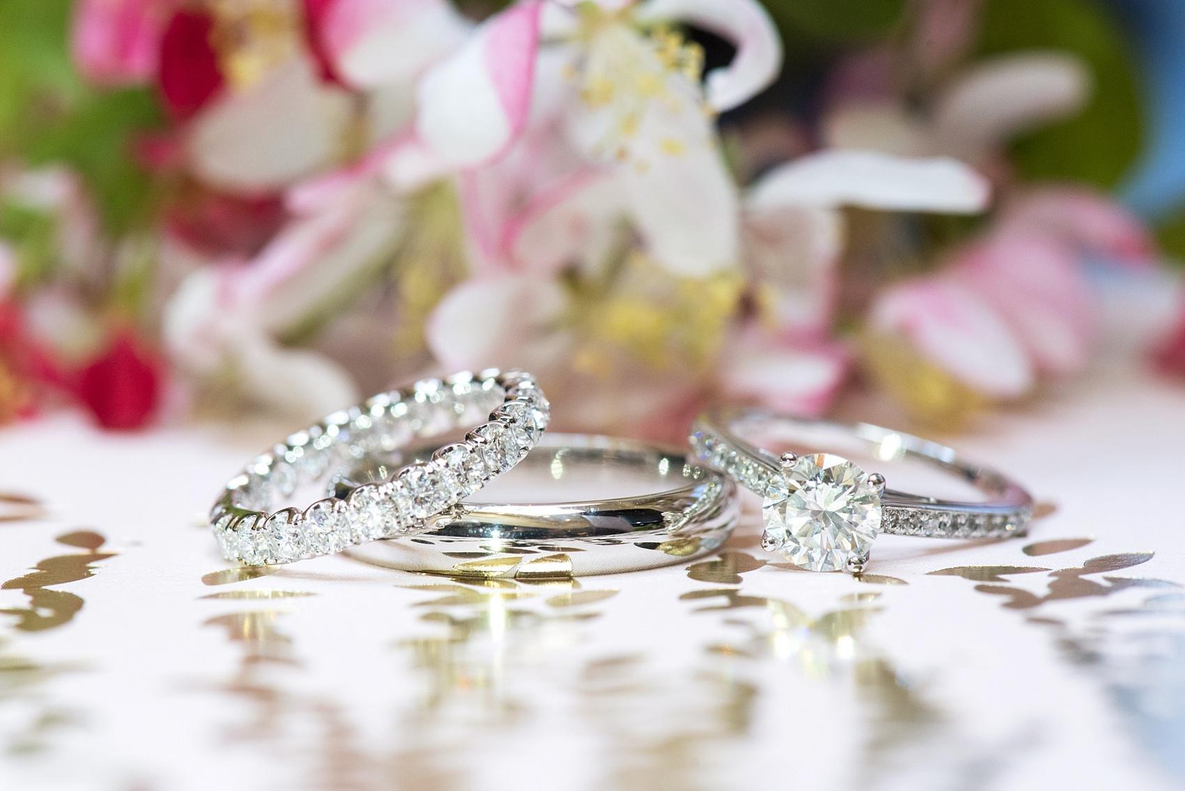 Photo by Mikkel Paige photography of white gold wedding band, eternity diamond wedding ring and round diamond engagement ring.
