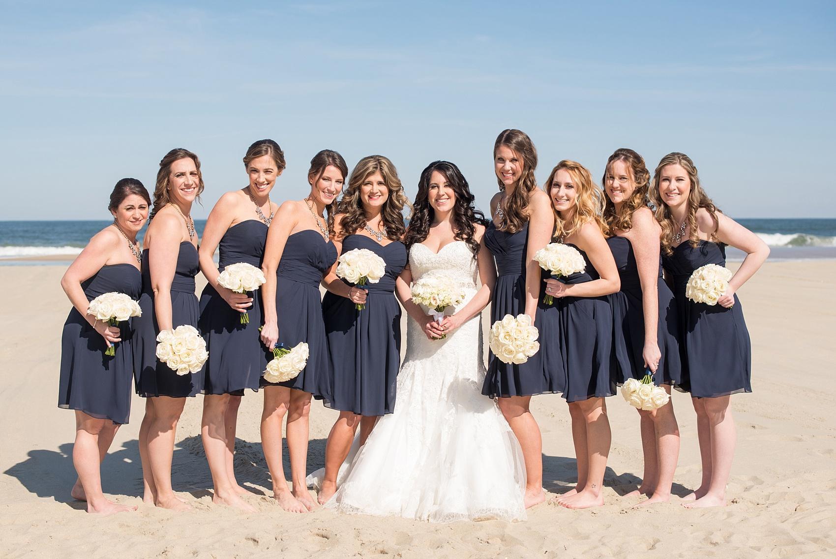 Photo by Mikkel Paige photography. Bridesmaids in navy chiffon short dresses with white rose bouquets.