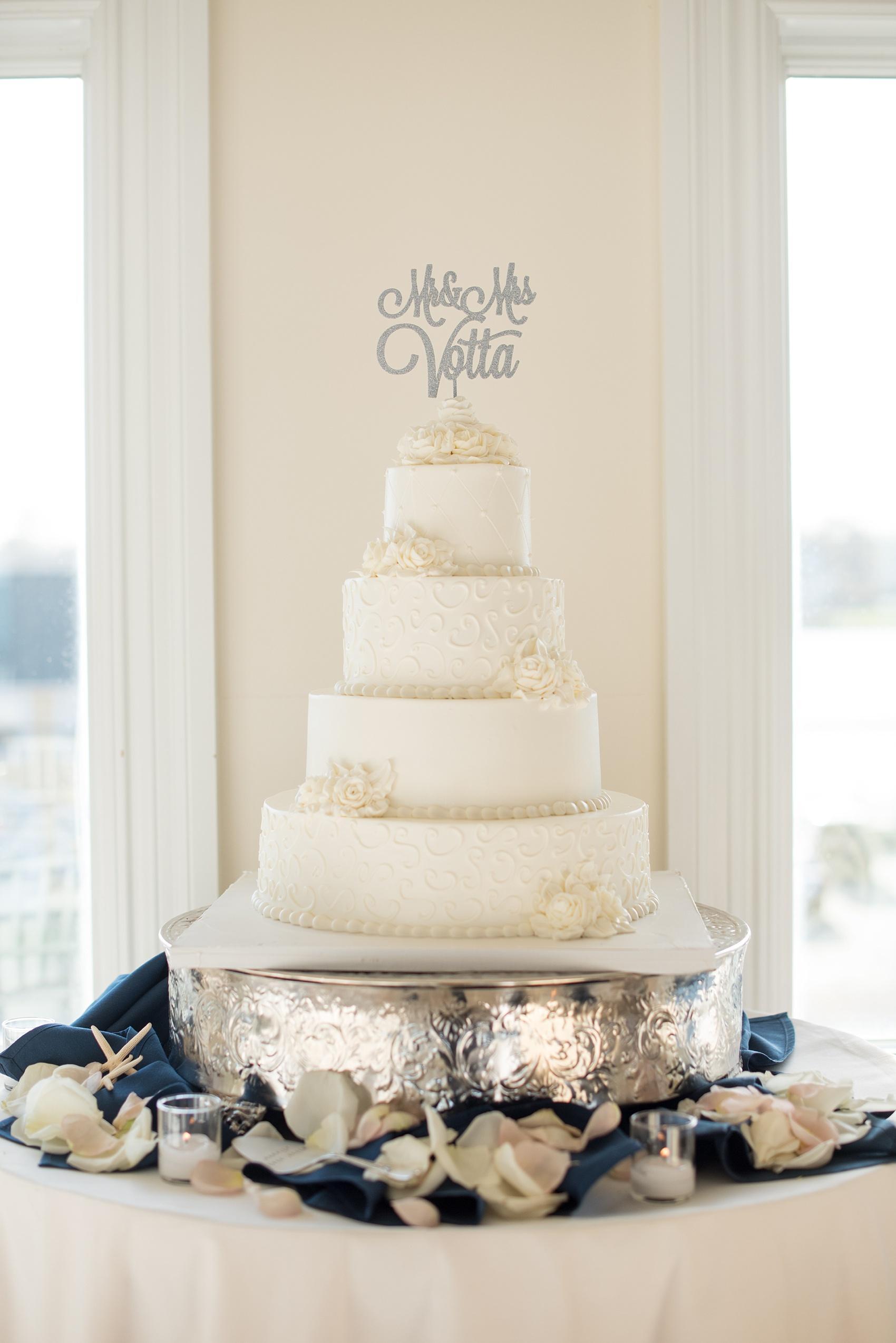 Photo by Mikkel Paige photography. White tiered buttercream wedding cake and custom silver last name topper.
