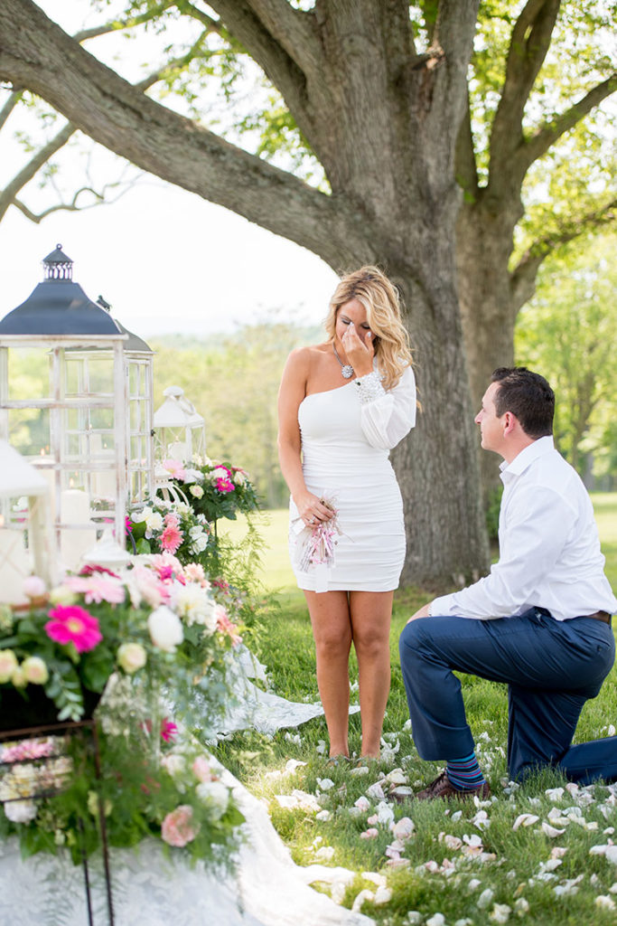 Mikkel Paige Photography, NYC wedding photographer, captures a marriage proposal at Glenmere Mansion in the lower Hudson Valley region. Overlooking a lake he gets down on one knee to ask 