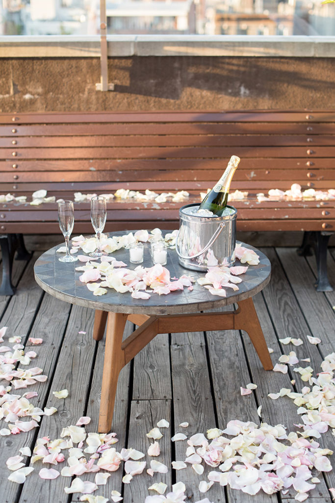 NYC rooftop proposal photos by Mikkel Paige Photography, New York wedding photographer. Champagne toast and rose petal carpet.