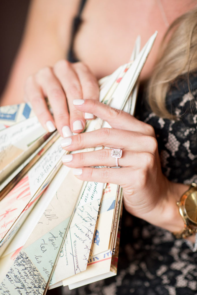NYC Proposal Photographer Mikkel Paige Photography captures a travel themed marriage proposal in Columbus Circle with a rectangle diamond engagement ring and paper airplanes.