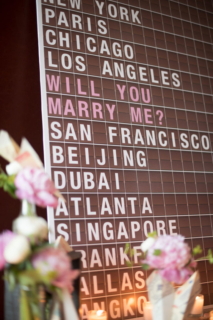 NYC Proposal Photographer Mikkel Paige Photography captures a travel themed marriage proposal in Columbus Circle with calligraphy on paper airplanes.