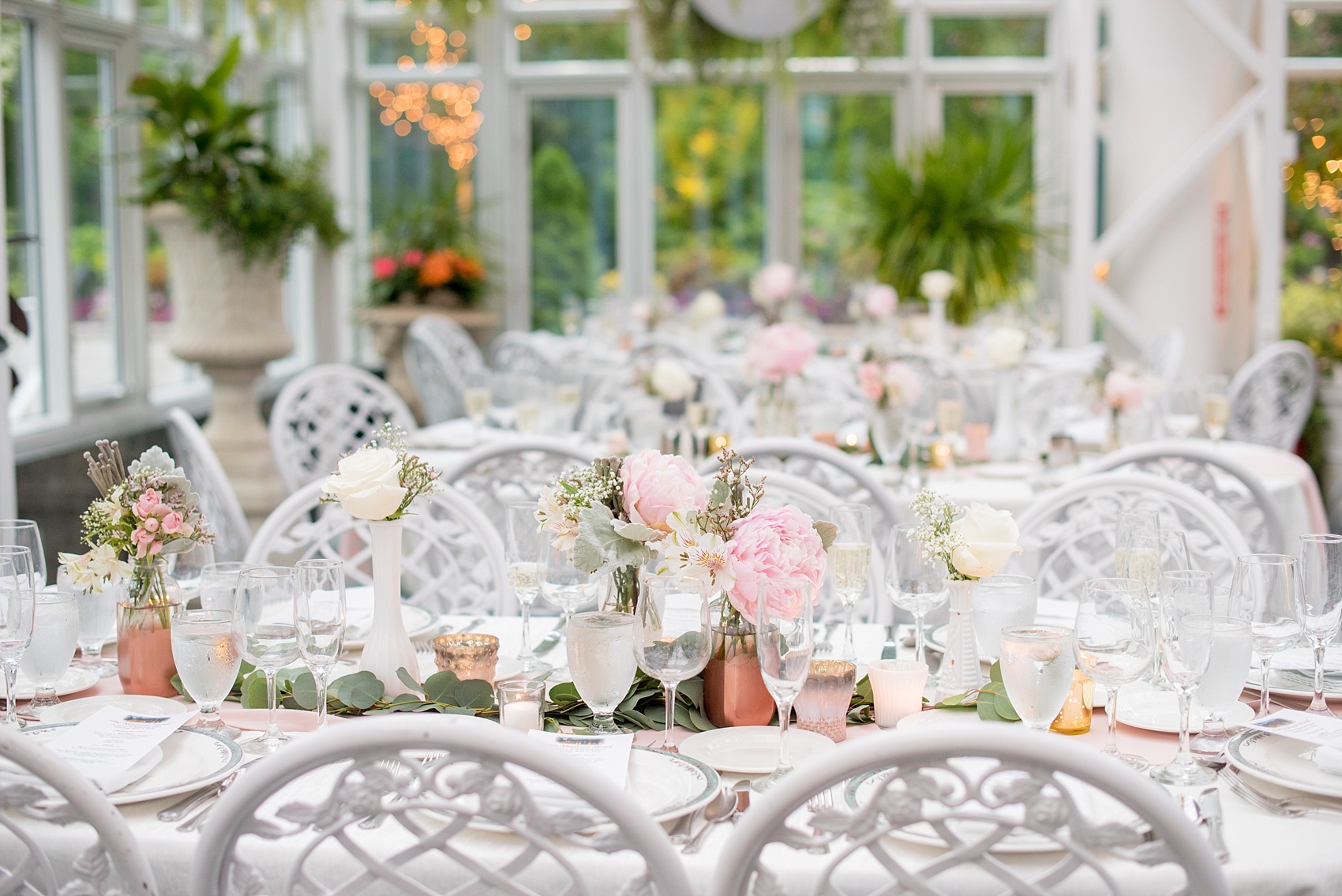 Mikkel Paige Photography photo of a wedding at the Madison Hotel in NJ. Photo of the white table at the reception in The Conservatory with pink peonies in bud vases.