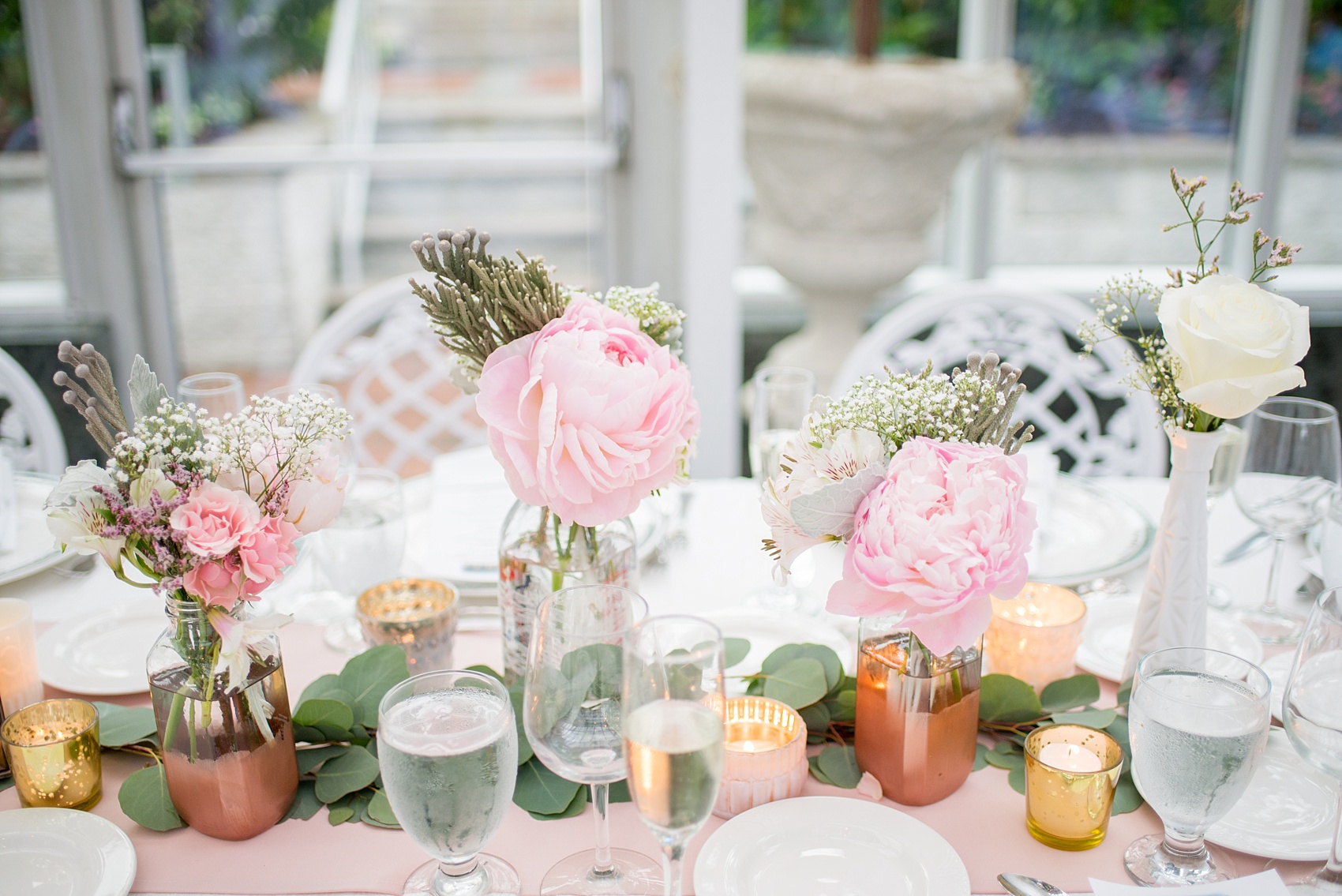 Mikkel Paige Photography photo of a wedding at the Madison Hotel in NJ. Photo of the white table at the reception in The Conservatory with pink peonies in bud vases.