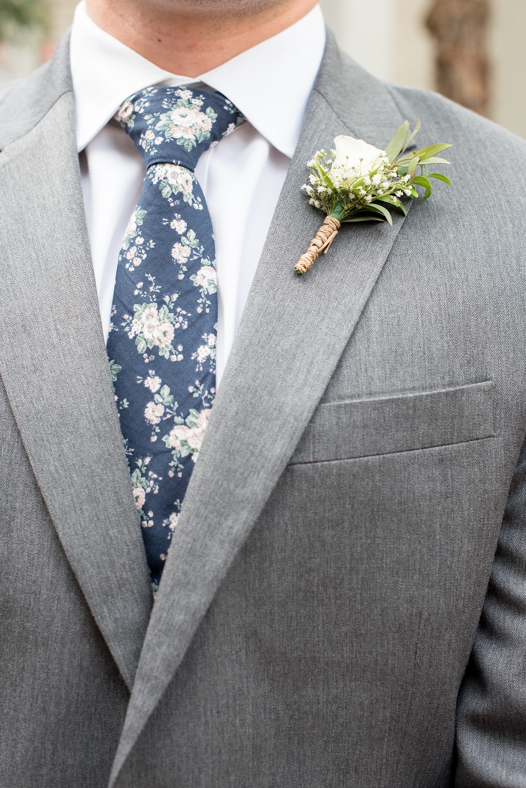 Mikkel Paige Photography photo of a wedding at Madison Hotel in NJ with the groomsmen in floral navy ties and grey suits and rose boutonnieres tied with twine.