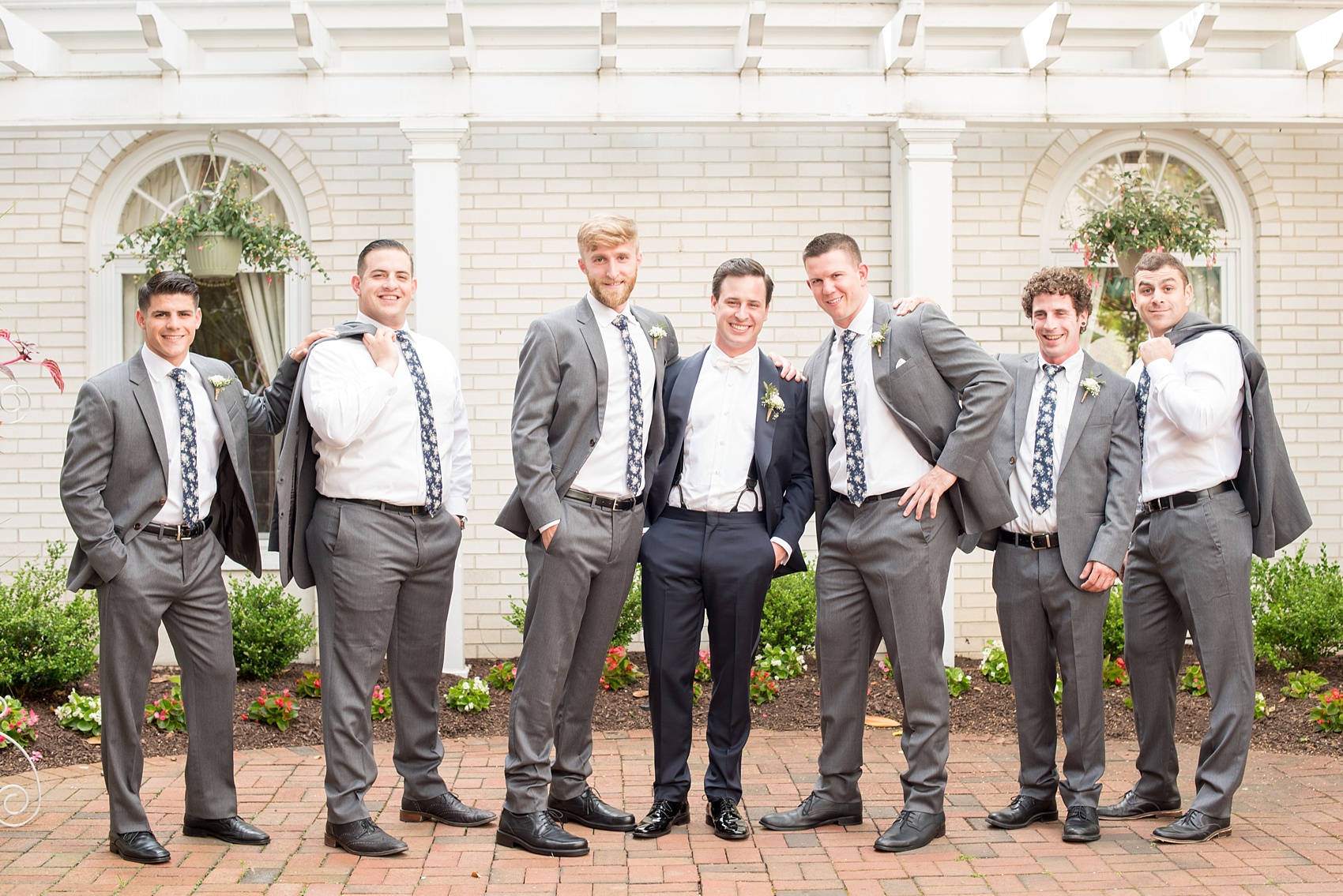 Mikkel Paige Photography photo of a wedding at Madison Hotel in NJ with the groomsmen in floral navy ties and grey suits.