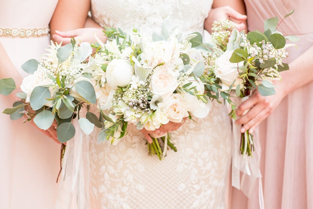 Mikkel Paige Photography photo of a wedding at Madison Hotel in NJ with the bridal party in light pink mismatched dresses with white rose and eucalyptus bouquets with long ribbons and the bride in a beaded BHLDN gown.