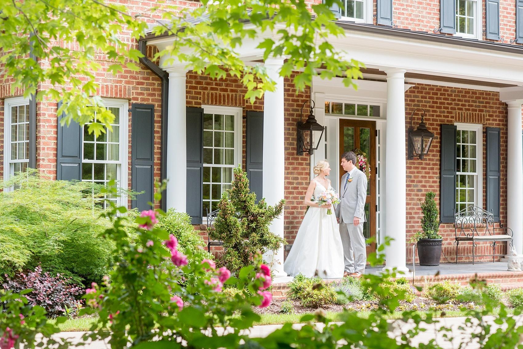 Mikkel Paige Photography pictures of a wedding in downtown Raleigh. Photo of the bride and groom on a picturesque porch of a home filled with roses.