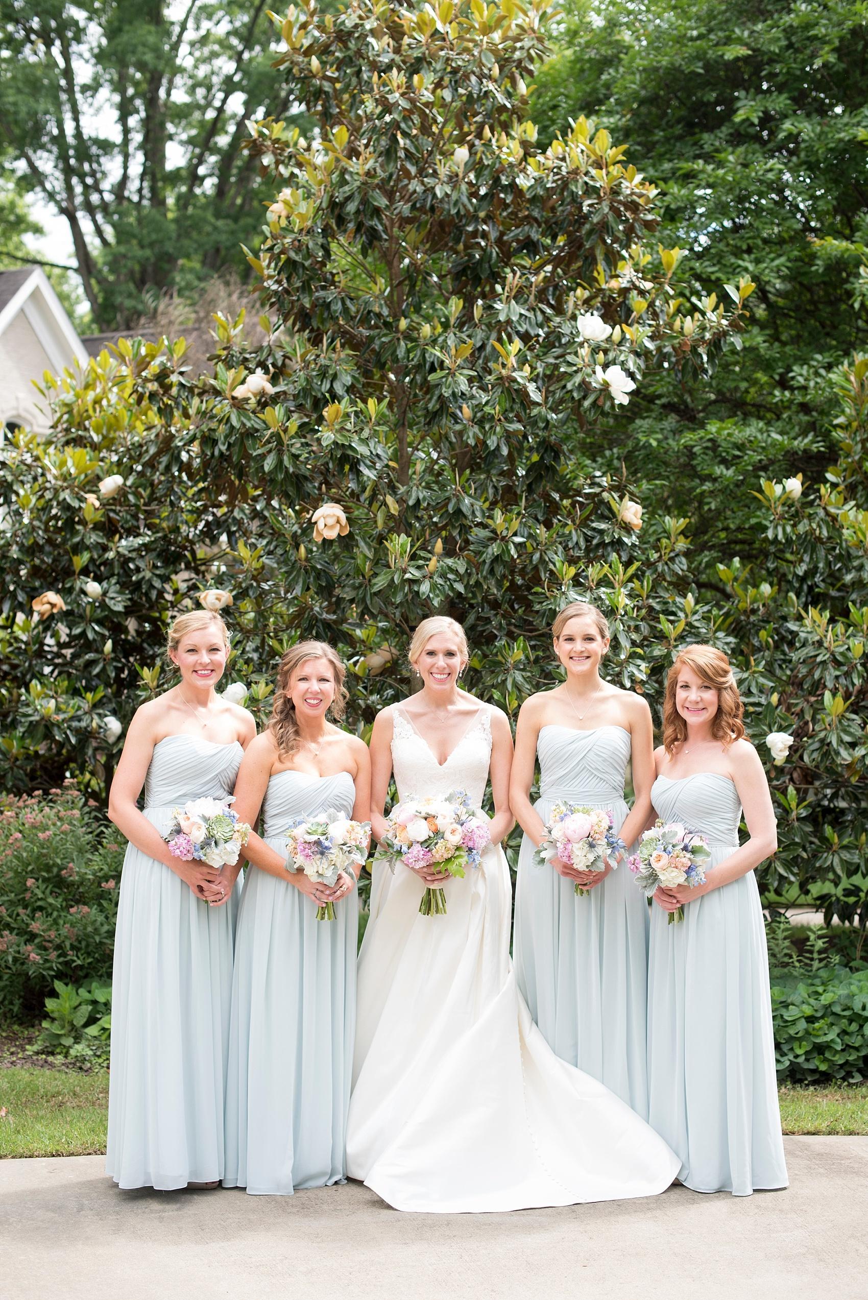 Mikkel Paige Photography pictures of a wedding in downtown Raleigh. Photo of the bride and her bridesmaids in strapless blue chiffon gowns.
