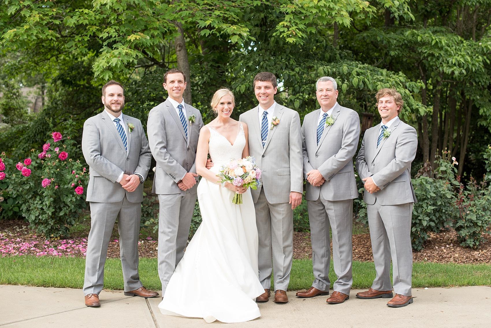 Mikkel Paige Photography pictures of a wedding in downtown Raleigh. Photo of the bride with her groom and groomsmen in grey suits with blue ties.