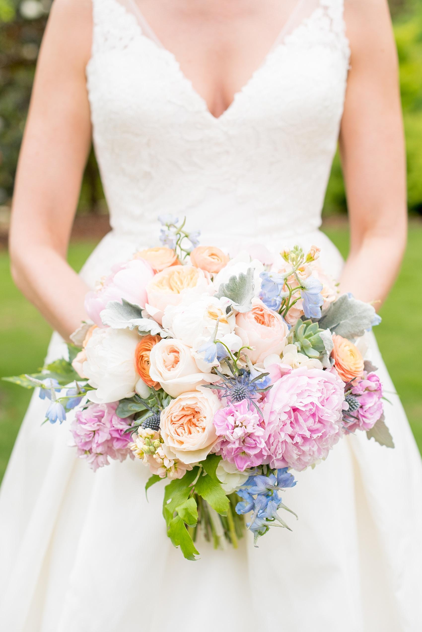 Mikkel Paige Photography photos of a downtown Raleigh wedding. Light blue details with planning by Sally Oakley. Image of the bride carrying a bouquet of peach garden roses, pink peonies and dusty miller.