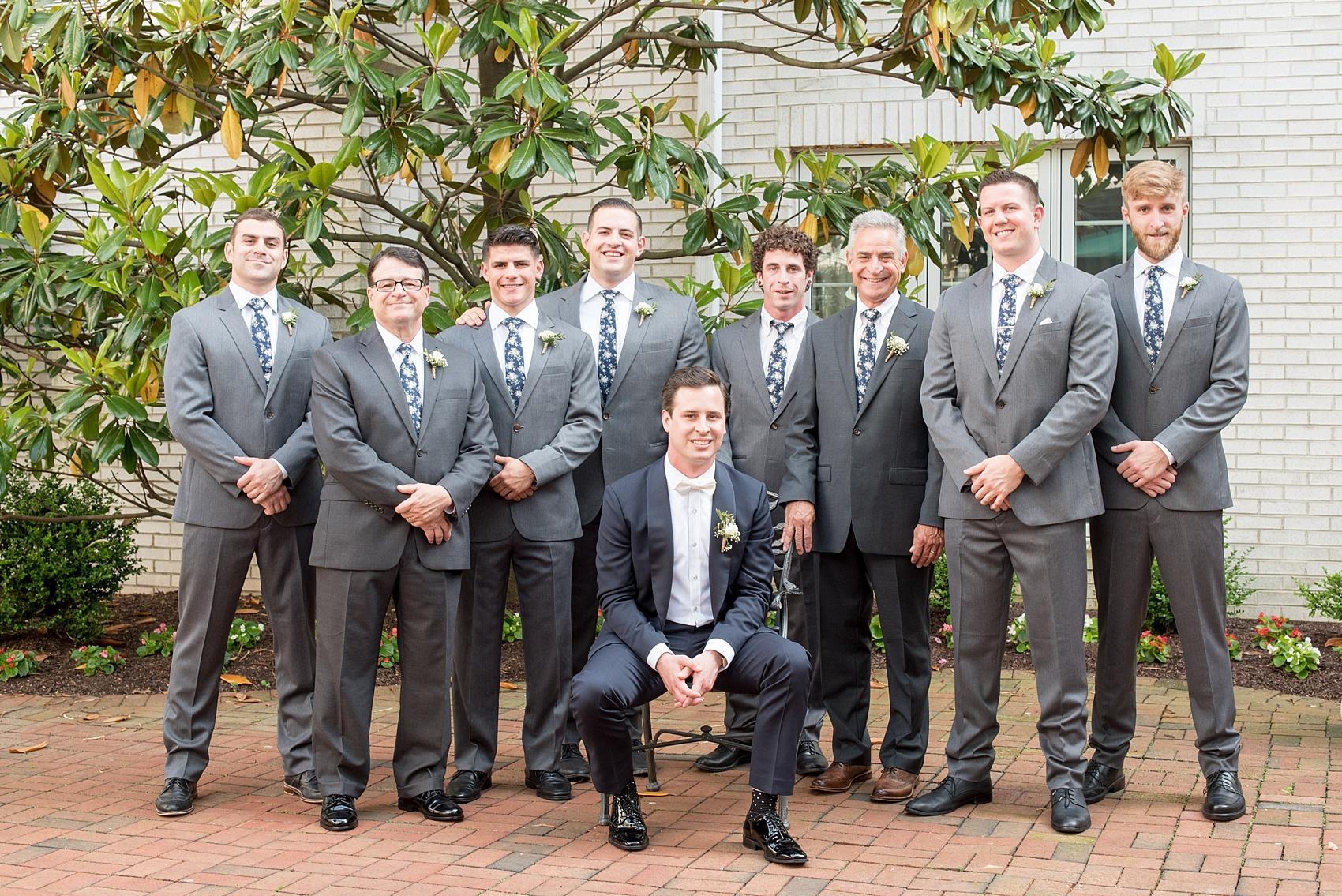 Mikkel Paige Photography captures groomsmen at a wedding at The Madison Hotel NJ with grey suits and floral navy ties.
