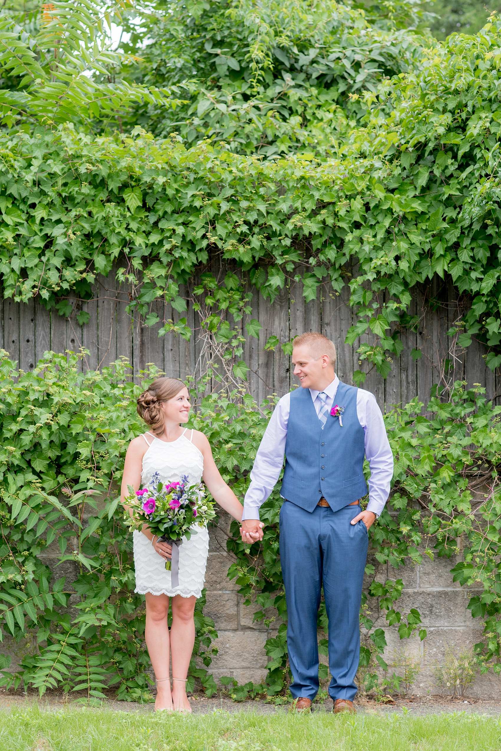 Mikkel Paige Photography photo of an anniversary session with light blue, navy and fuchsia pink accents with a bride and groom in a short white dress and blue suit and vest. 