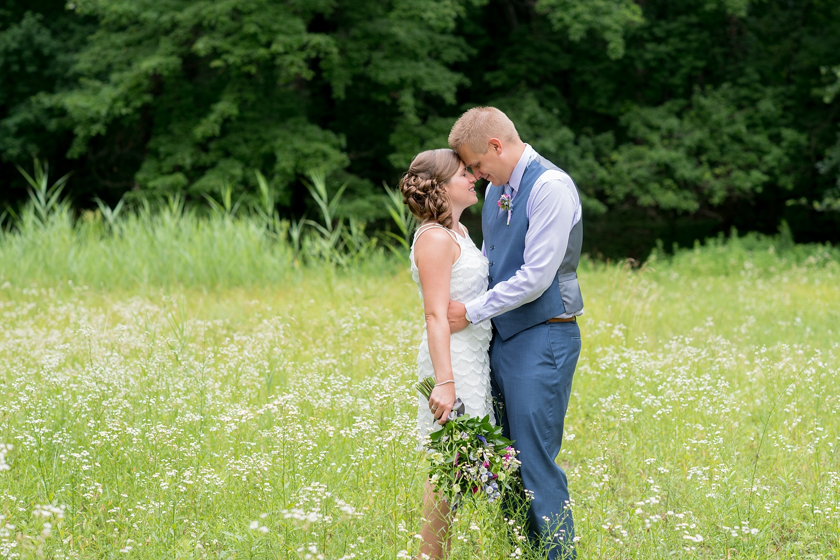 Mikkel Paige Photography photo of an anniversary session with light blue, navy and fuchsia pink accents with a bride and groom in a short white dress and blue suit and vest. 