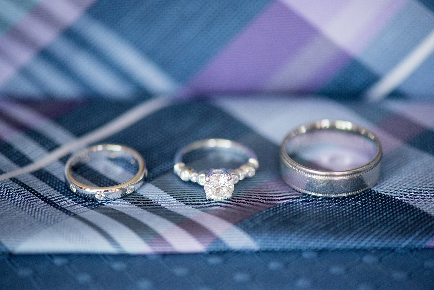 Mikkel Paige Photography photo of an anniversary session with the groom's plaid navy blue, light blue and purple tie and white gold wedding rings.